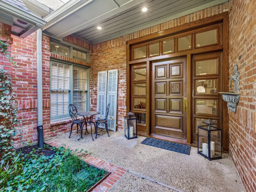 Brick exterior with a paneled wood-finish entry door, sidelights, and transom windows