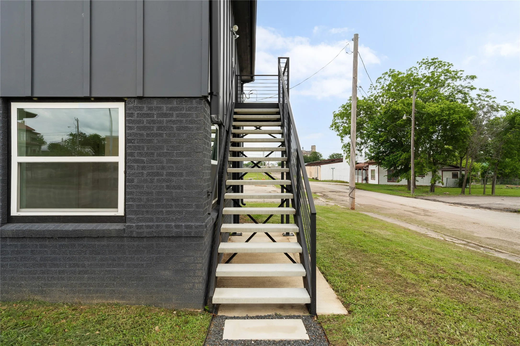 Exterior staircase featuring metal railings and concrete treads