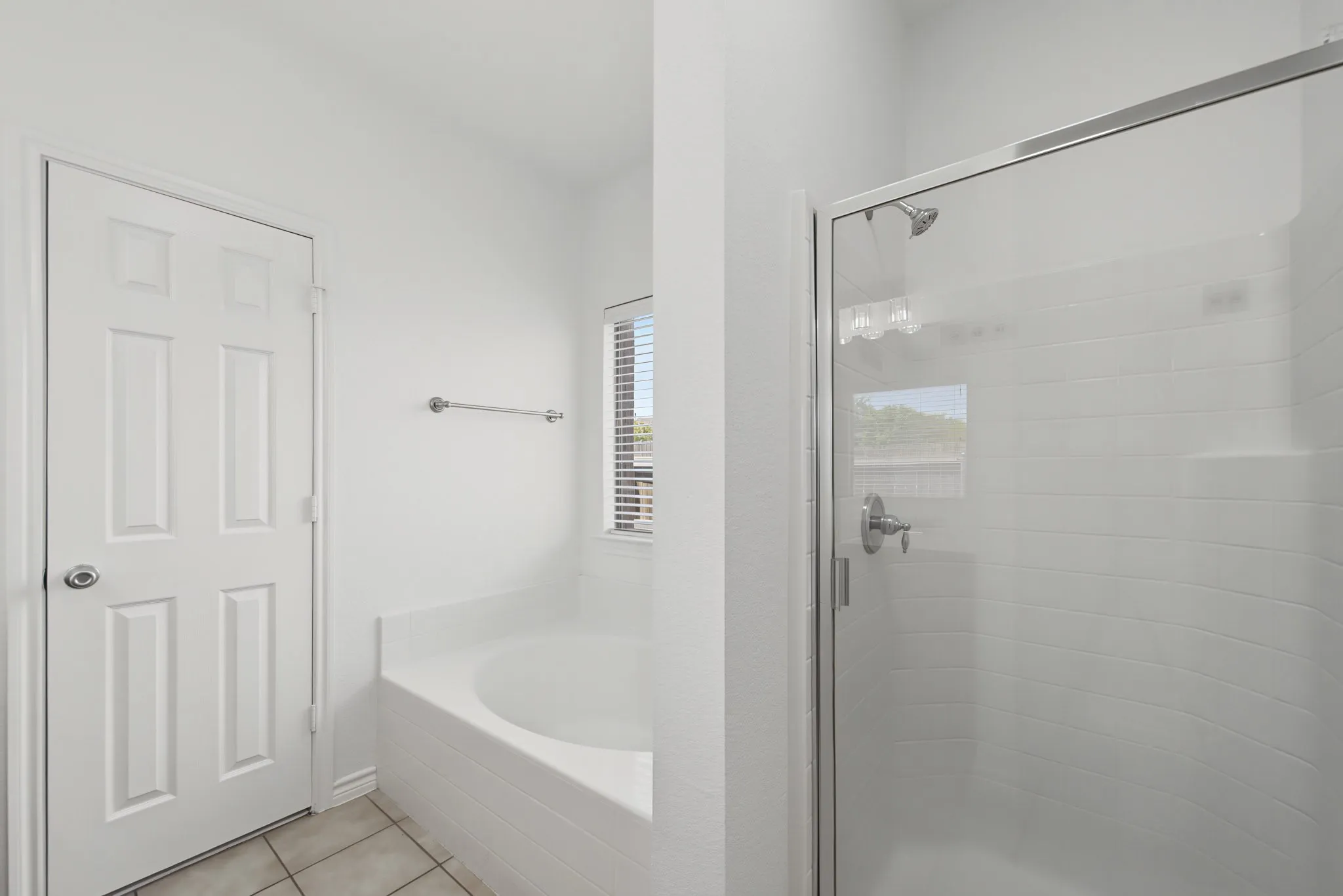 Built-in soaking tub, glass-enclosed shower, chrome fixtures, and tiled flooring