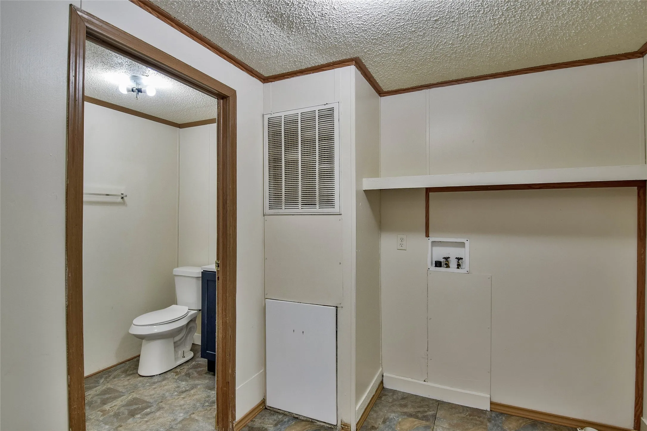 Dedicated laundry area with hookups, integrated shelving, and patterned flooring