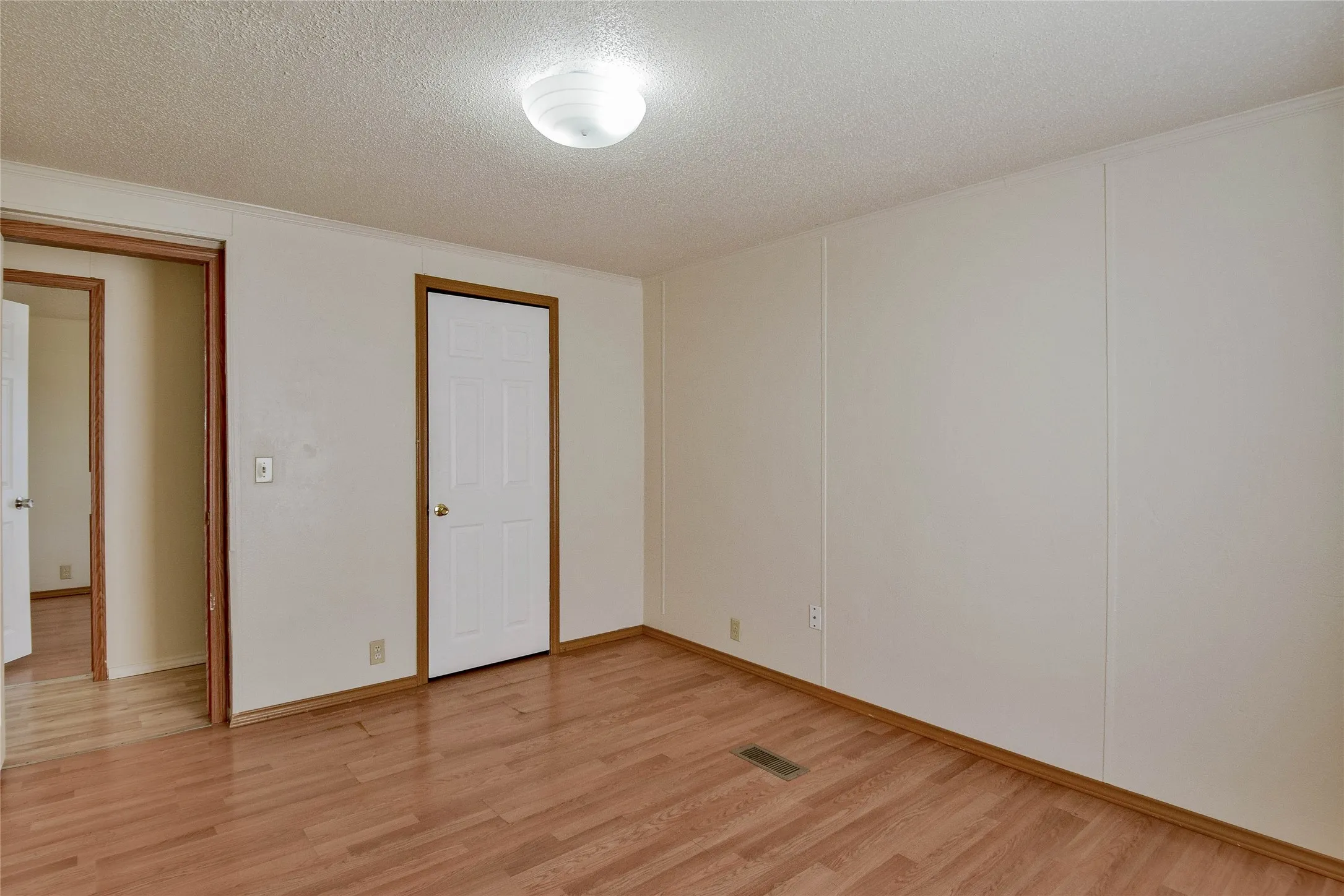 Wood-look vinyl  flooring with white paneled walls and a white ceiling