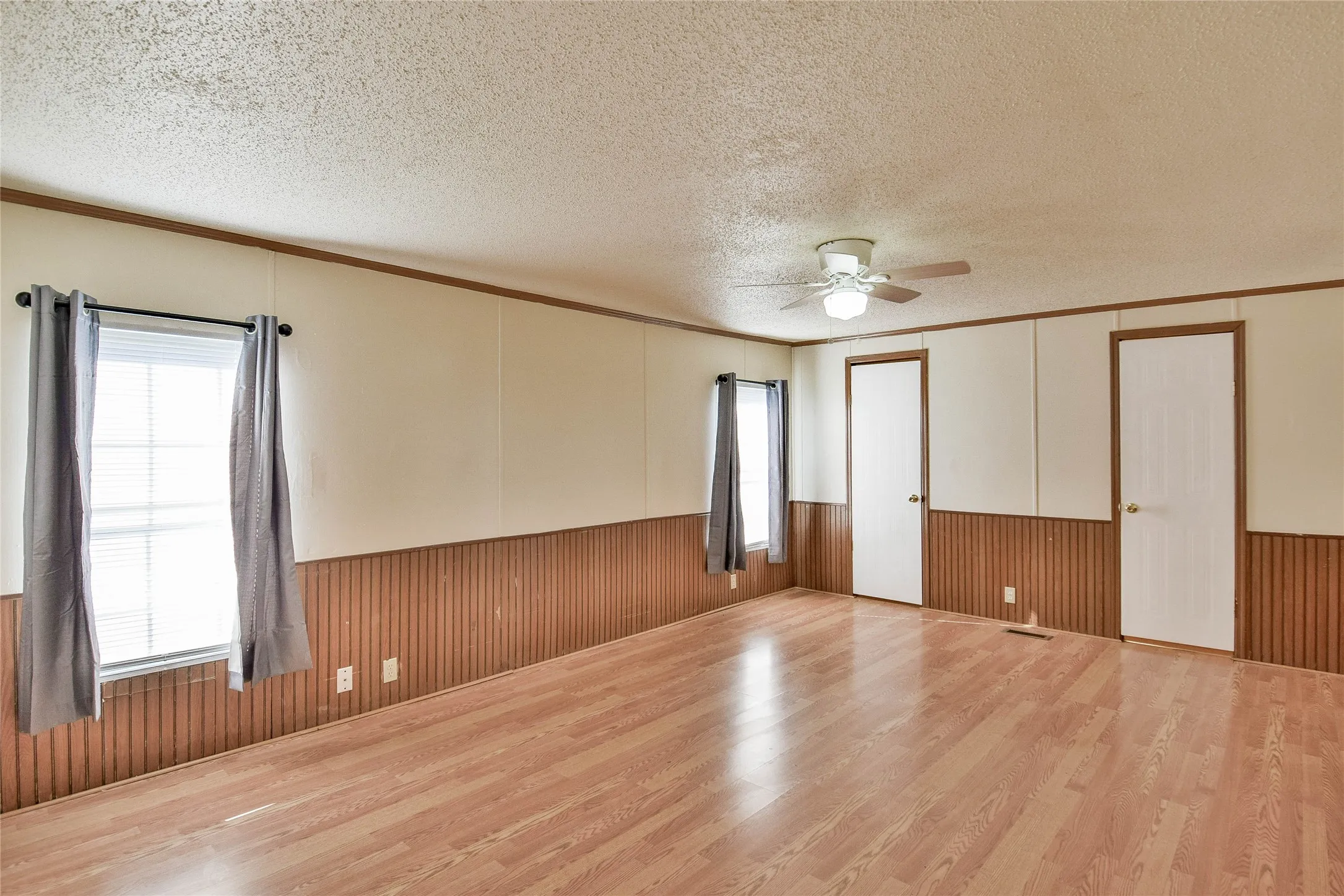 Wood-look finish flooring throughout, two panel doors, and two windows
