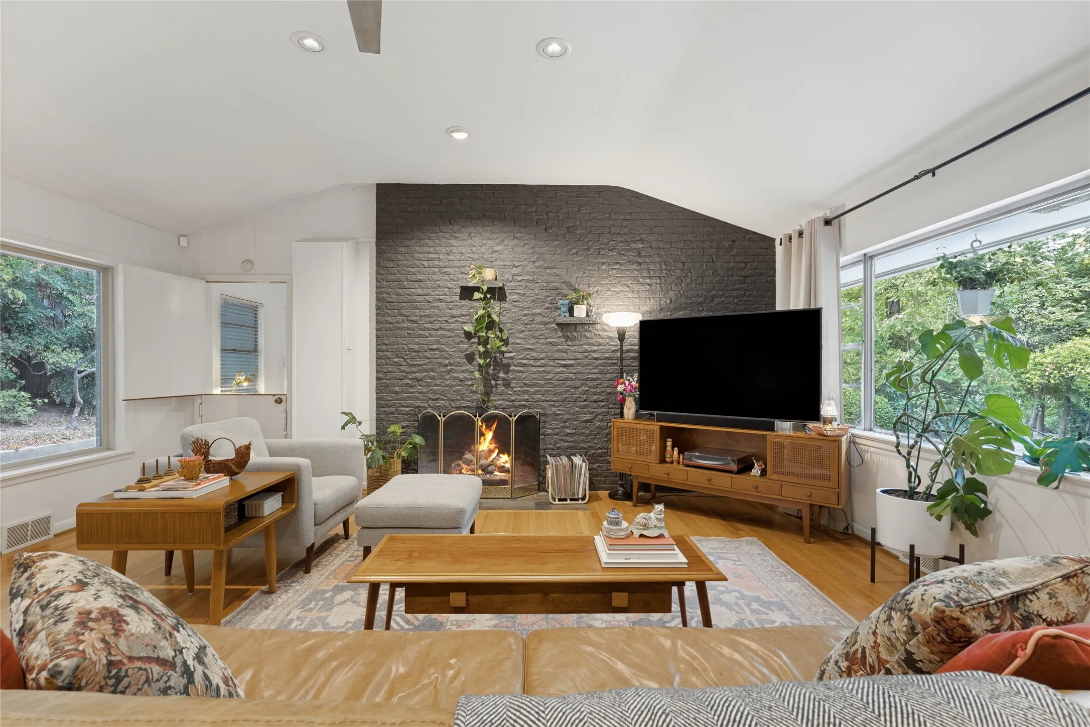 Hardwood floors and a dramatic gas fireplace anchor the vaulted Living Room.