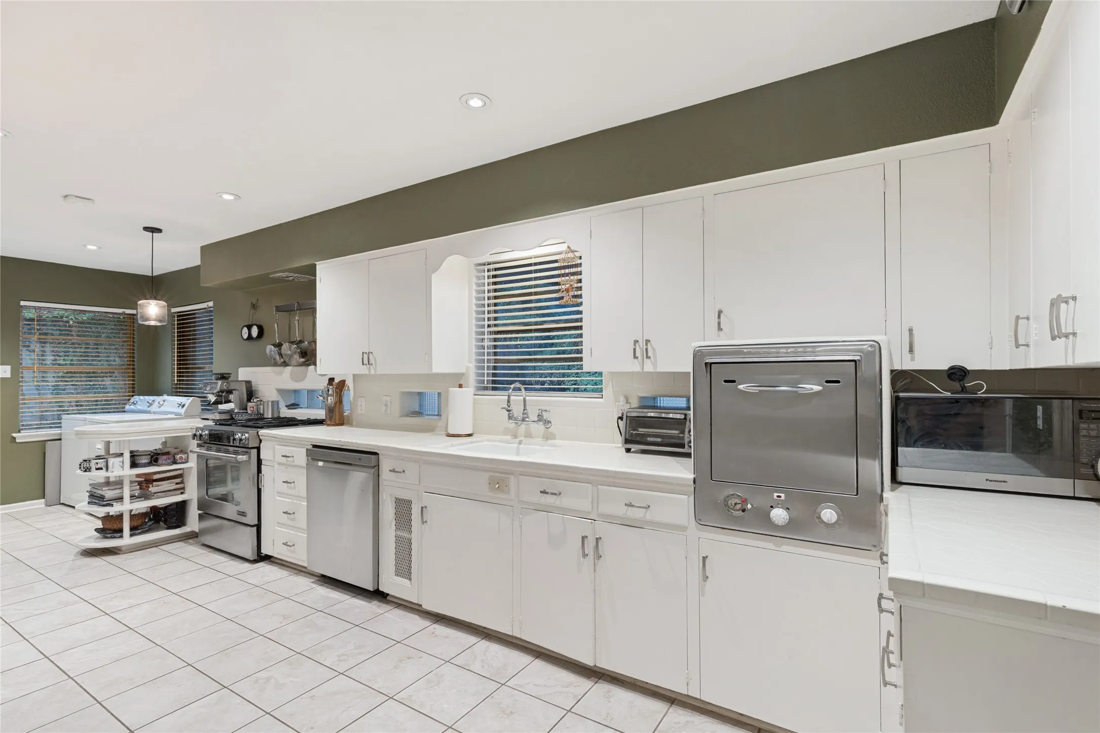 The original Thermador electric oven remains in place—now used for storage—alongside a modern gas range.