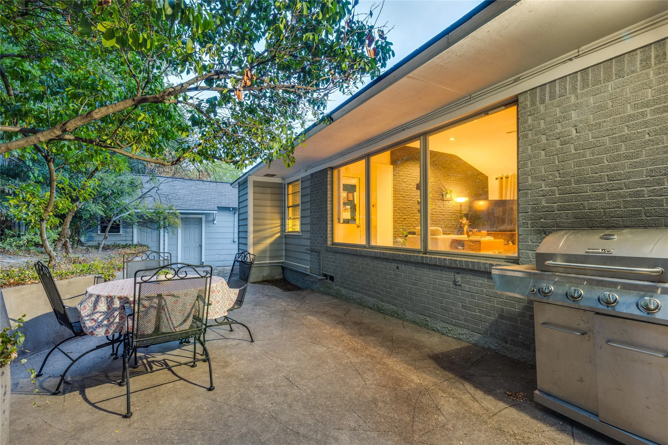 The Patio becomes an outdoor room beneath the trees, running the length of the house.
