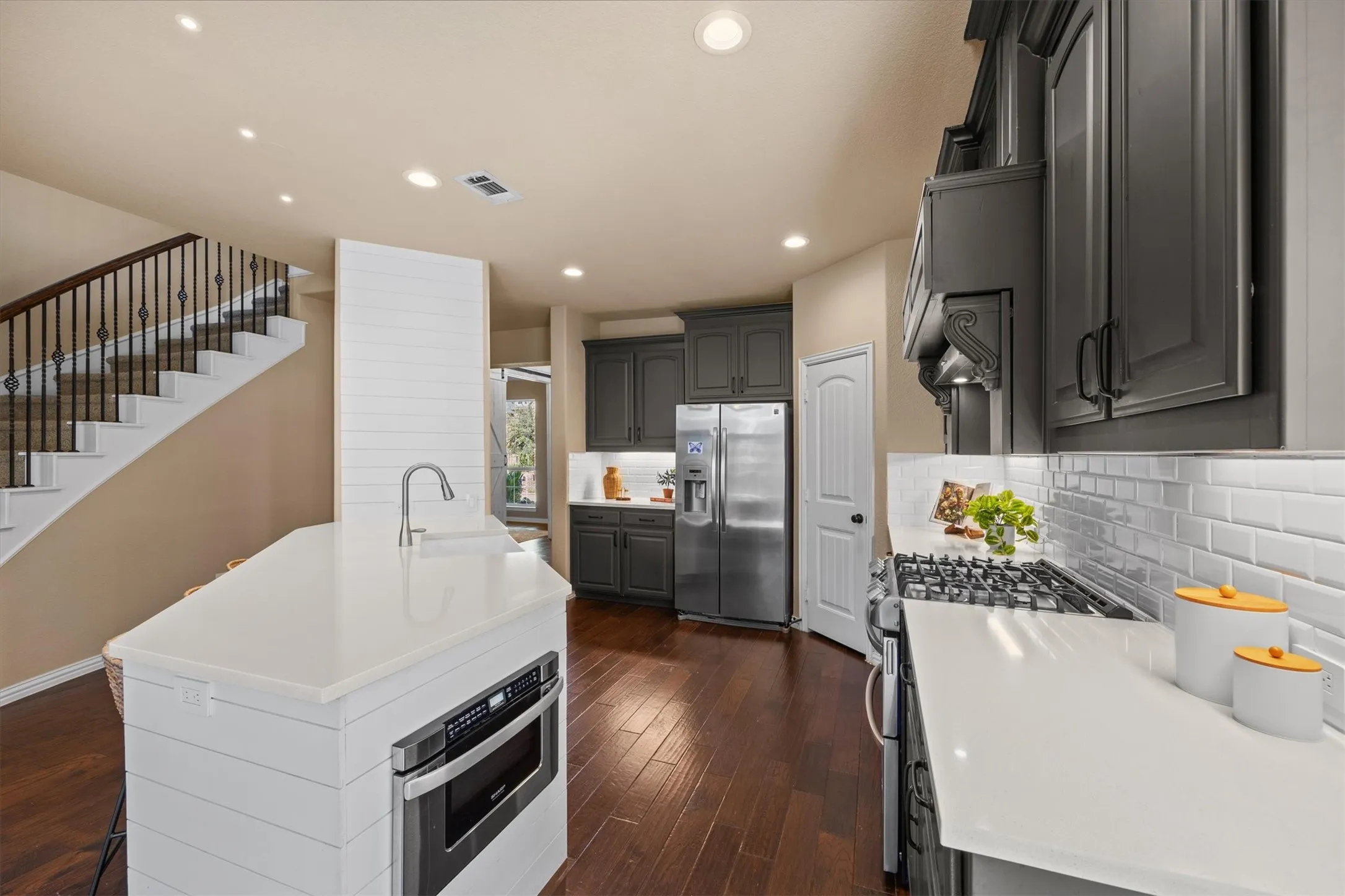 Contrasting cabinetry, light countertops, and a spacious island make this kitchen both stylish and functional!