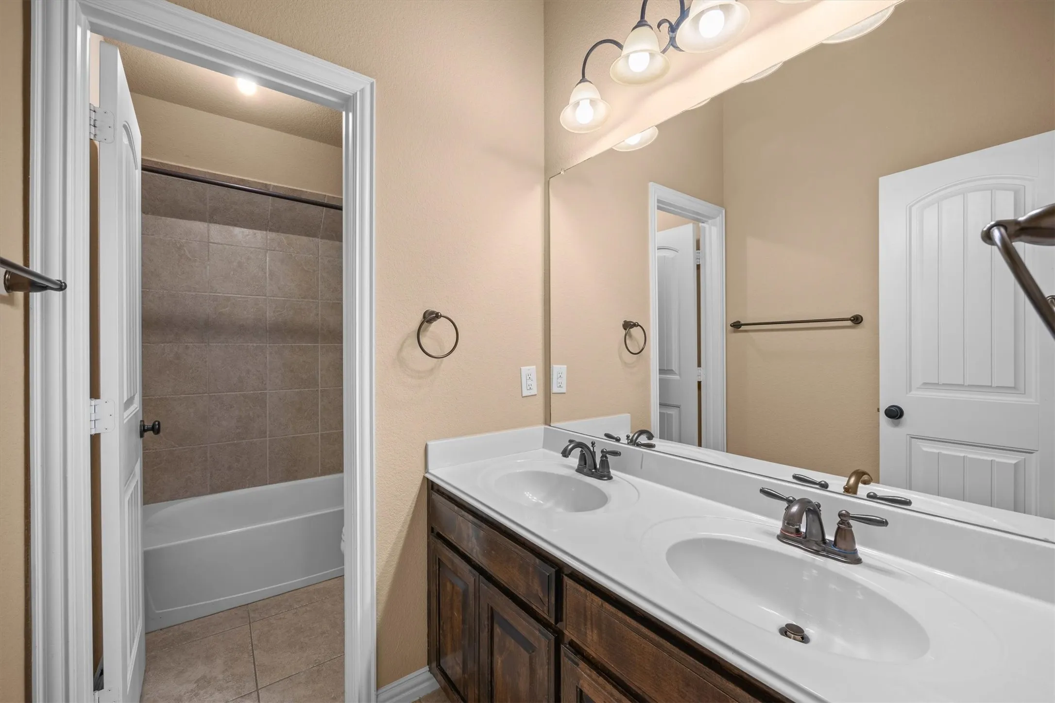 This secondary bathroom features a double-sink vanity and a separate tub and shower area.