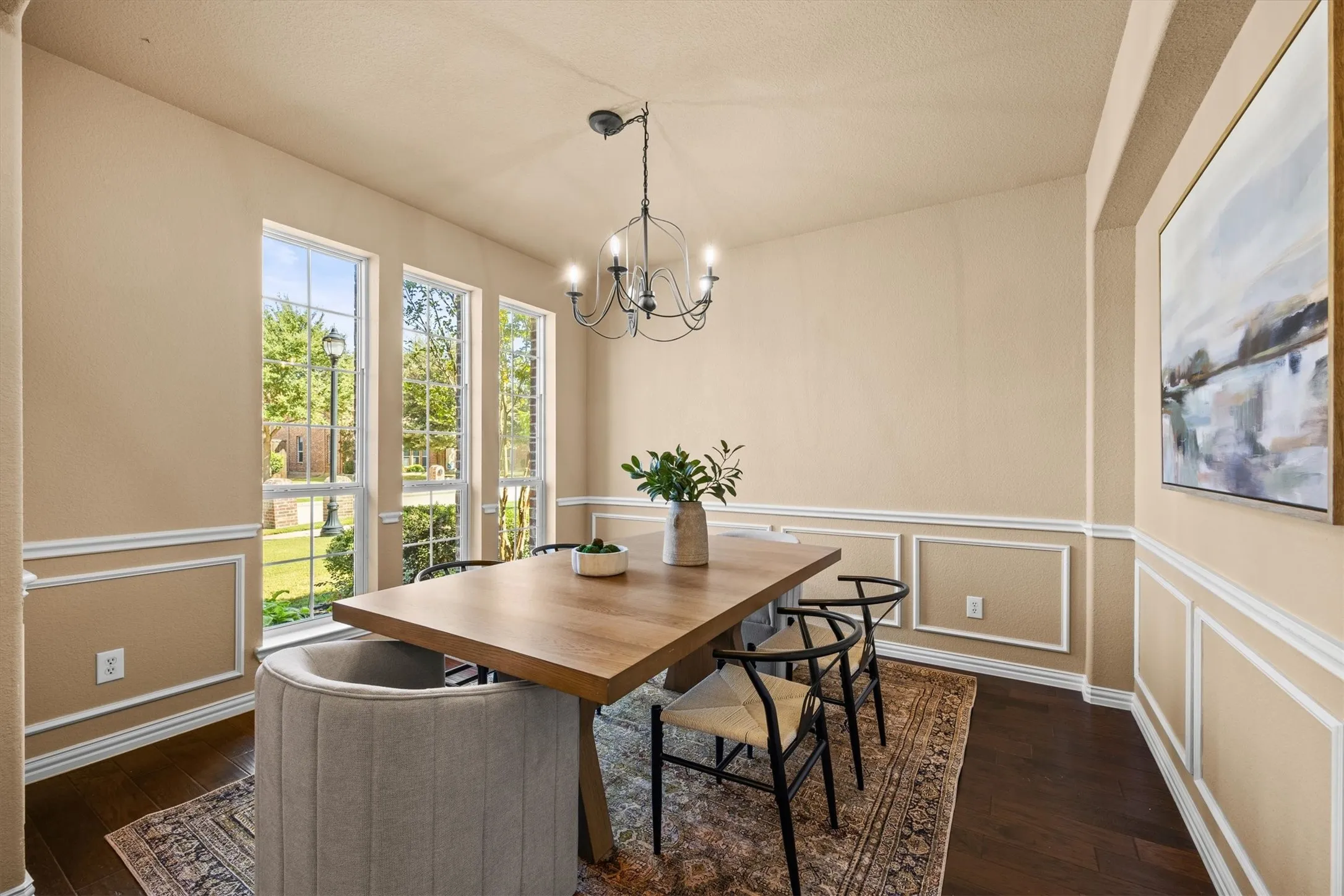 Gather around the table in this lovely dining room, featuring tall windows and classic decorative trim!
