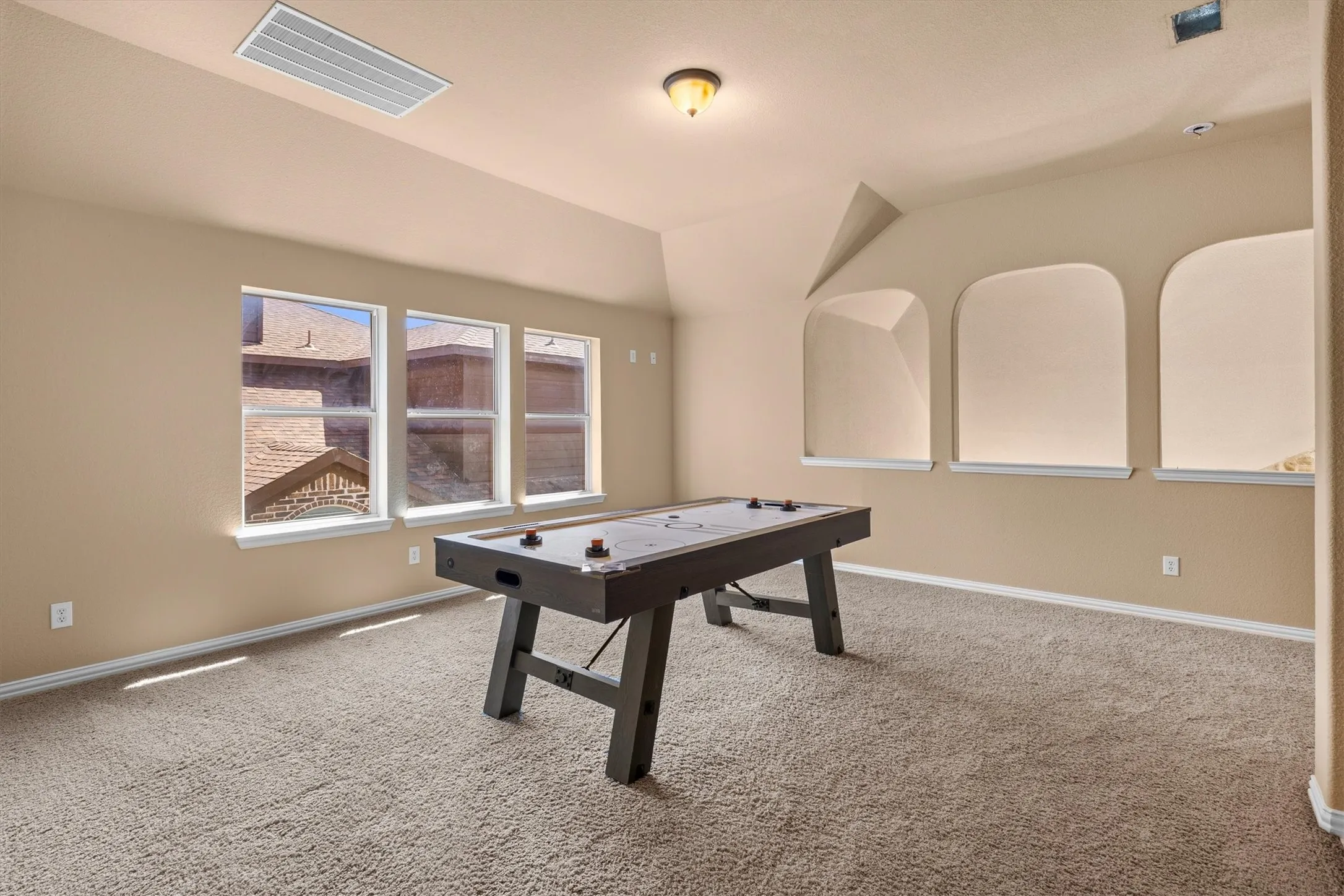 Arched openings add character to the game room while keeping the upstairs feeling open.