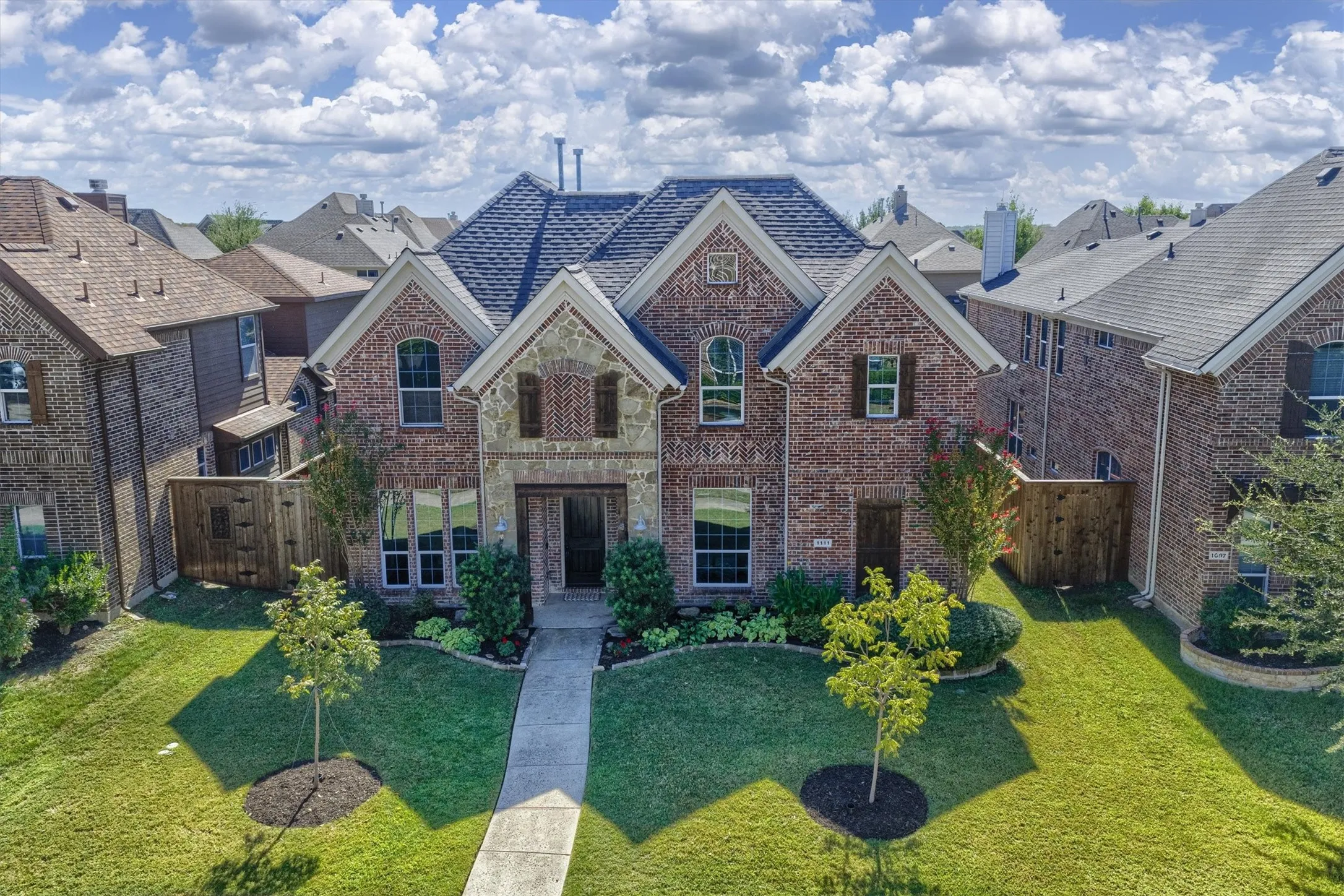 A landscaped front lawn and sidewalk-lined street complete the welcoming setting.