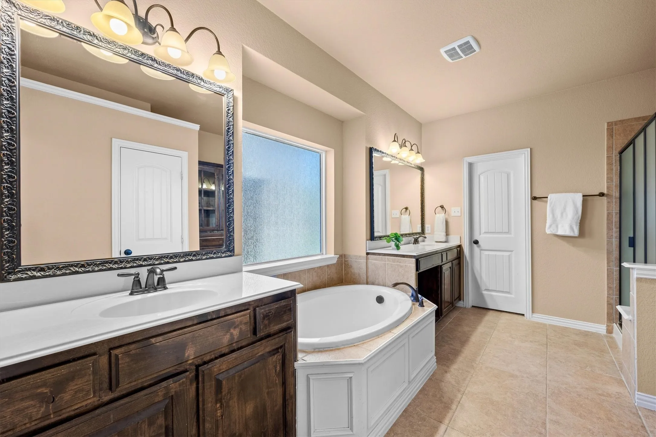 Separate vanities and a soaking tub give the primary bathroom plenty of room to unwind!