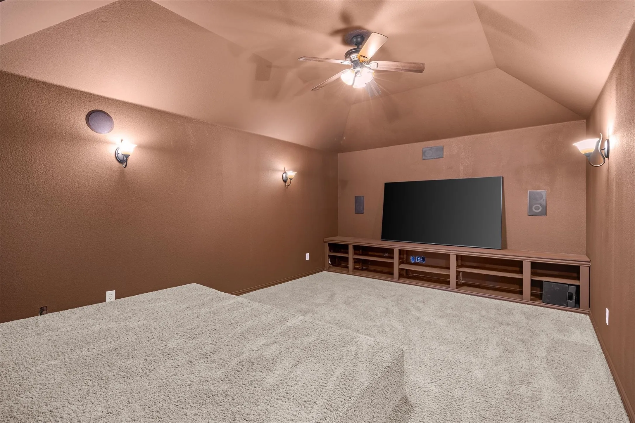 Bring movie night home in this dedicated media room with wall sconces and built-in storage!