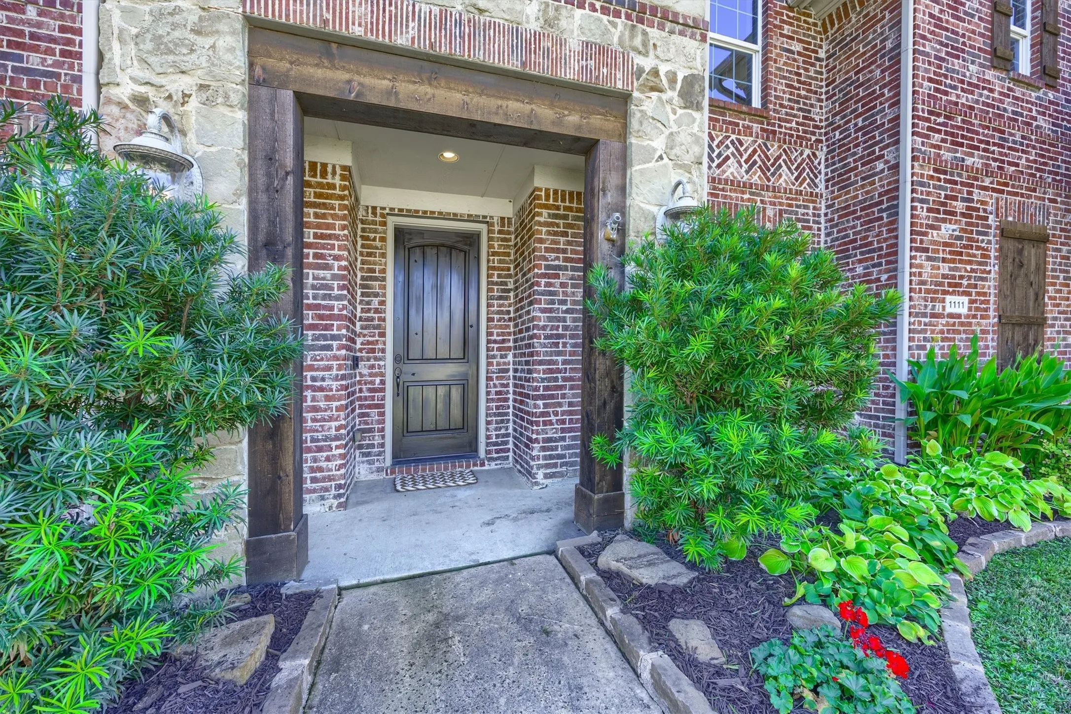 Beautiful stonework and colorful landscaping welcome you to the sheltered front entry.