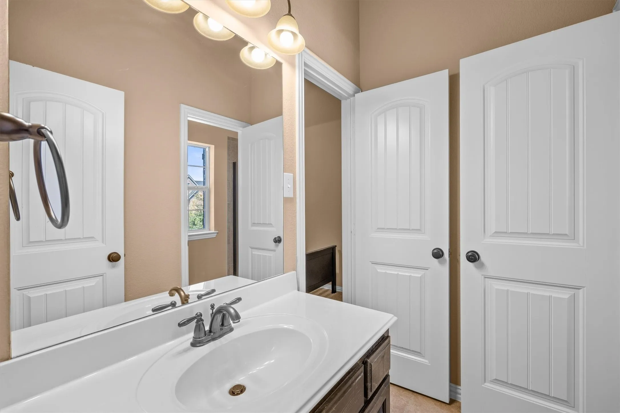 This additional bathroom offers a generous vanity counter and cabinet storage to keep everyday essentials close at hand.