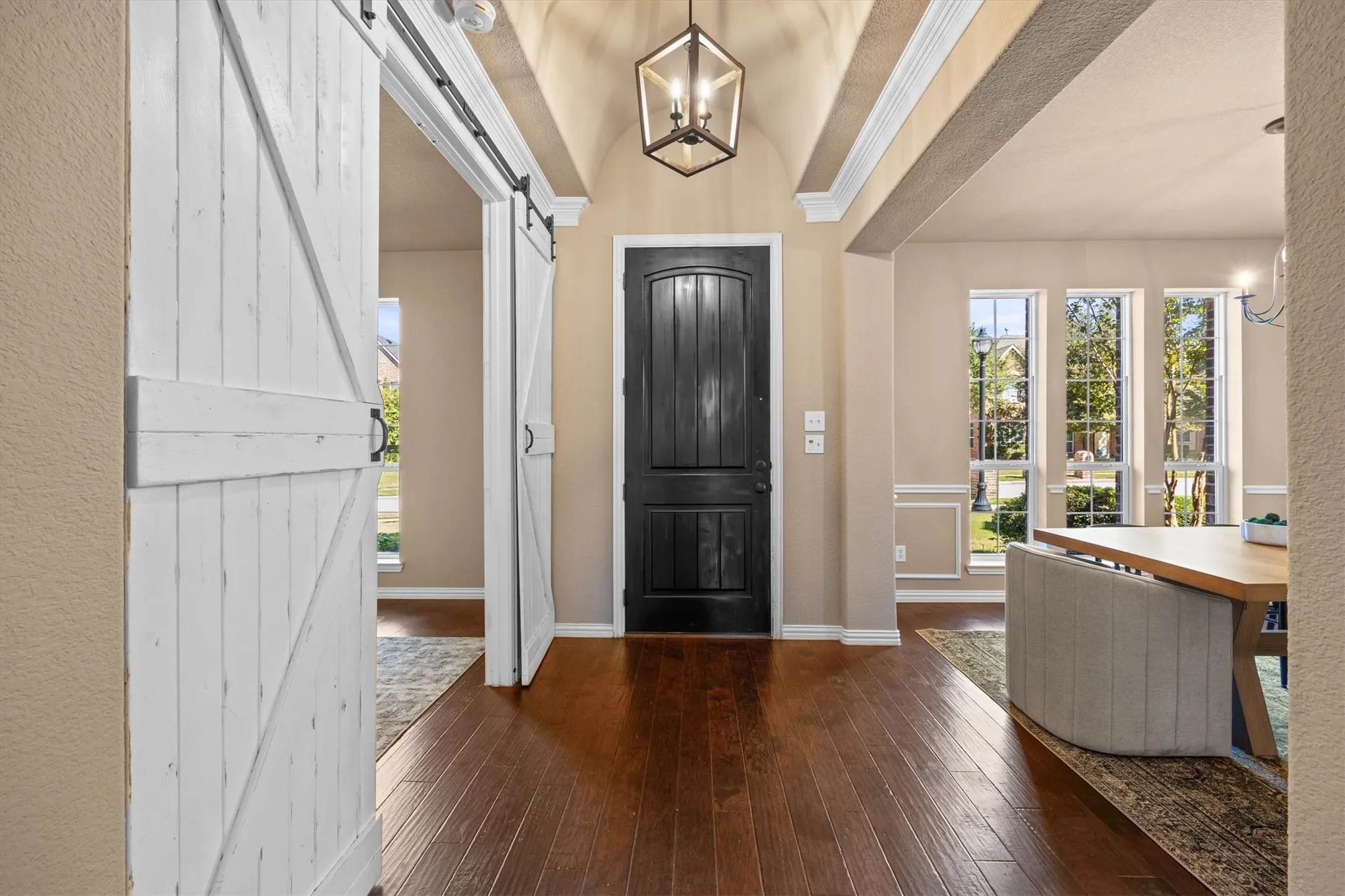 A welcoming entry with wood beams and sliding barn doors sets the tone for the home!