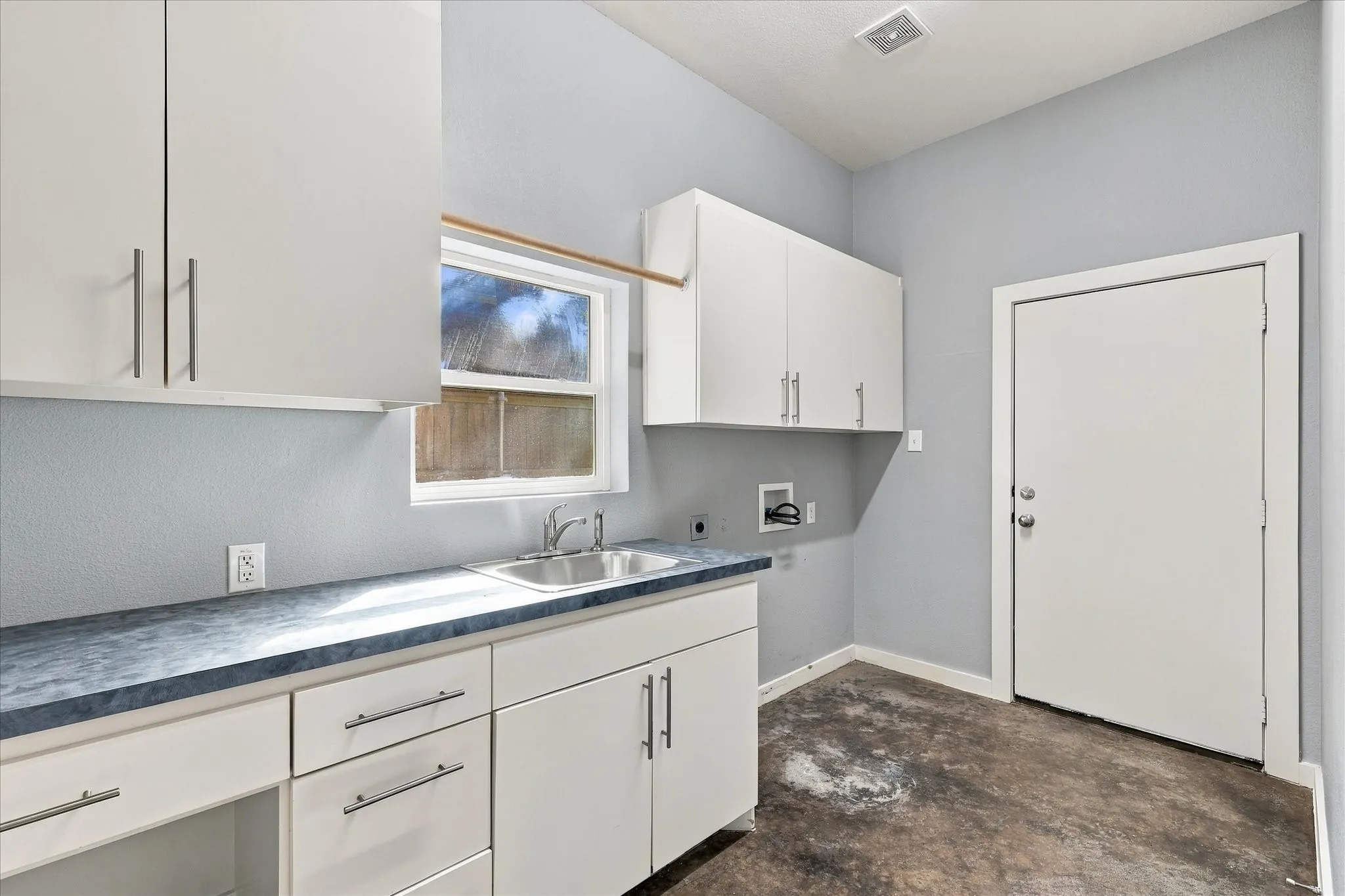 Utility room has a sink & lots of built-in cabinets for more storage.