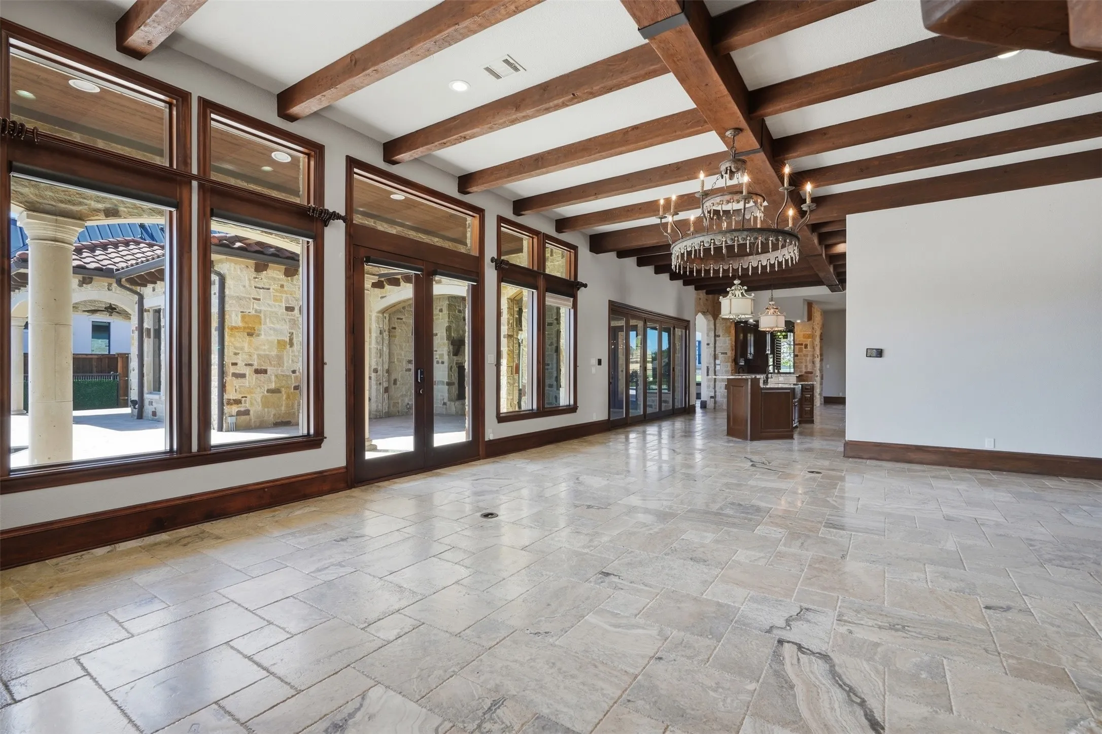 The massive open living room space is filled with natural light, showcasing views of the outdoor entertaining spaces and pristine pool.