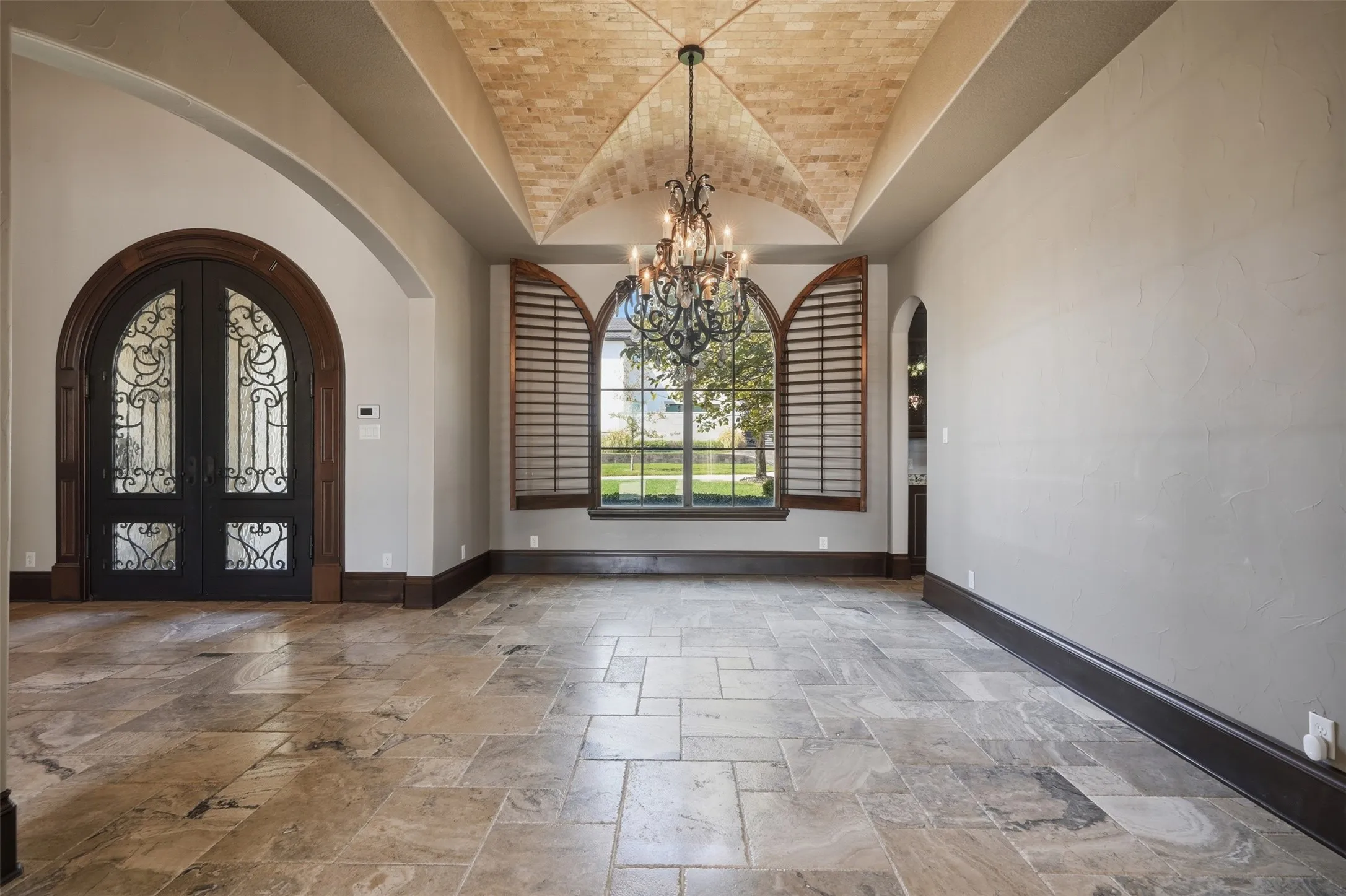 The formal dining room features a groin vault ceiling lined in tumbled marble and anchored by a crystal chandelier — a striking example of the craftsmanship and attention to detail found throughout this home.