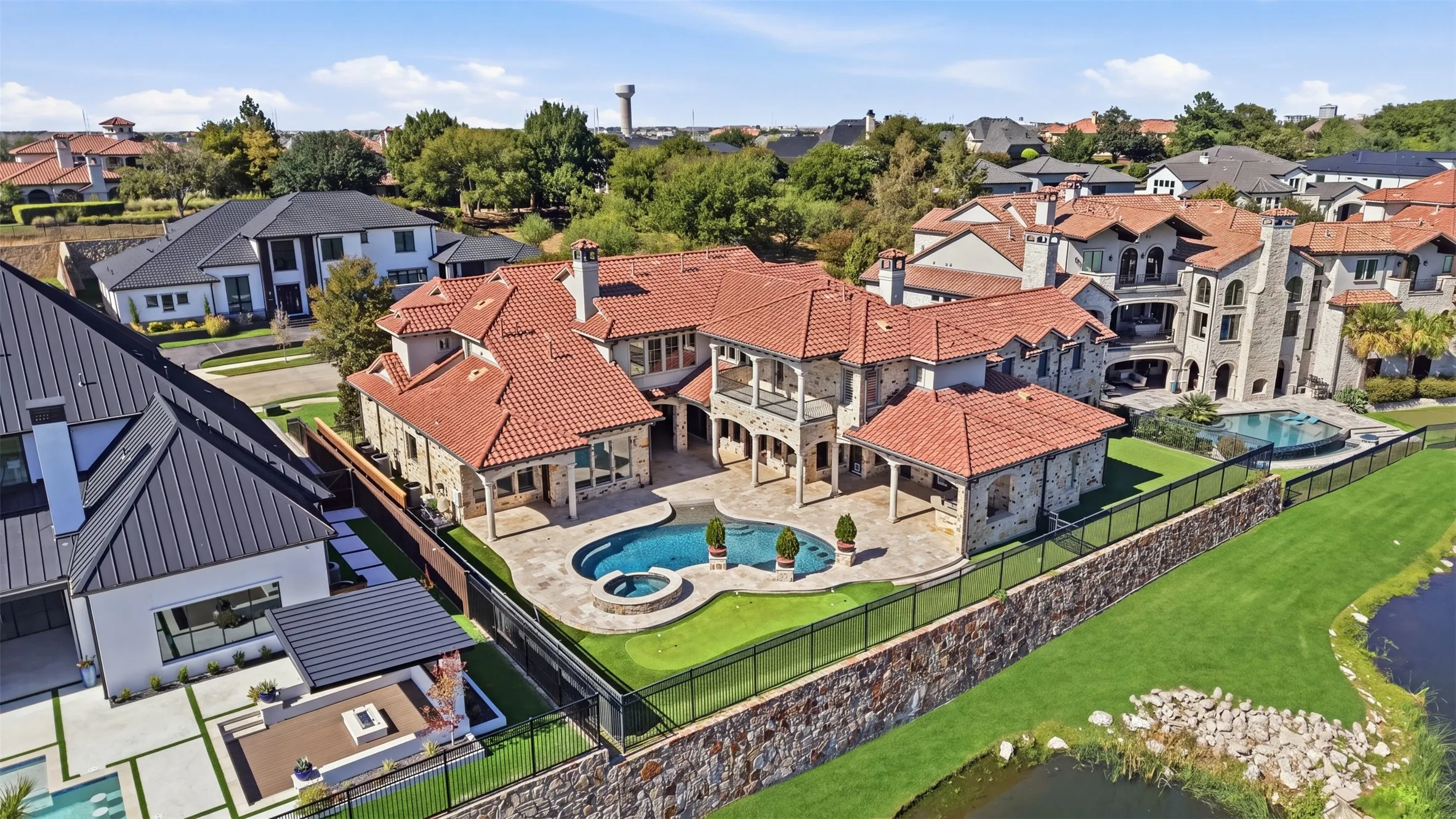 The backyard is designed for effortless entertaining, featuring an expansive patio with motorized screens to keep the mosquitos out, a custom pool and spa, a putting green, and a low-maintenance turf yard.