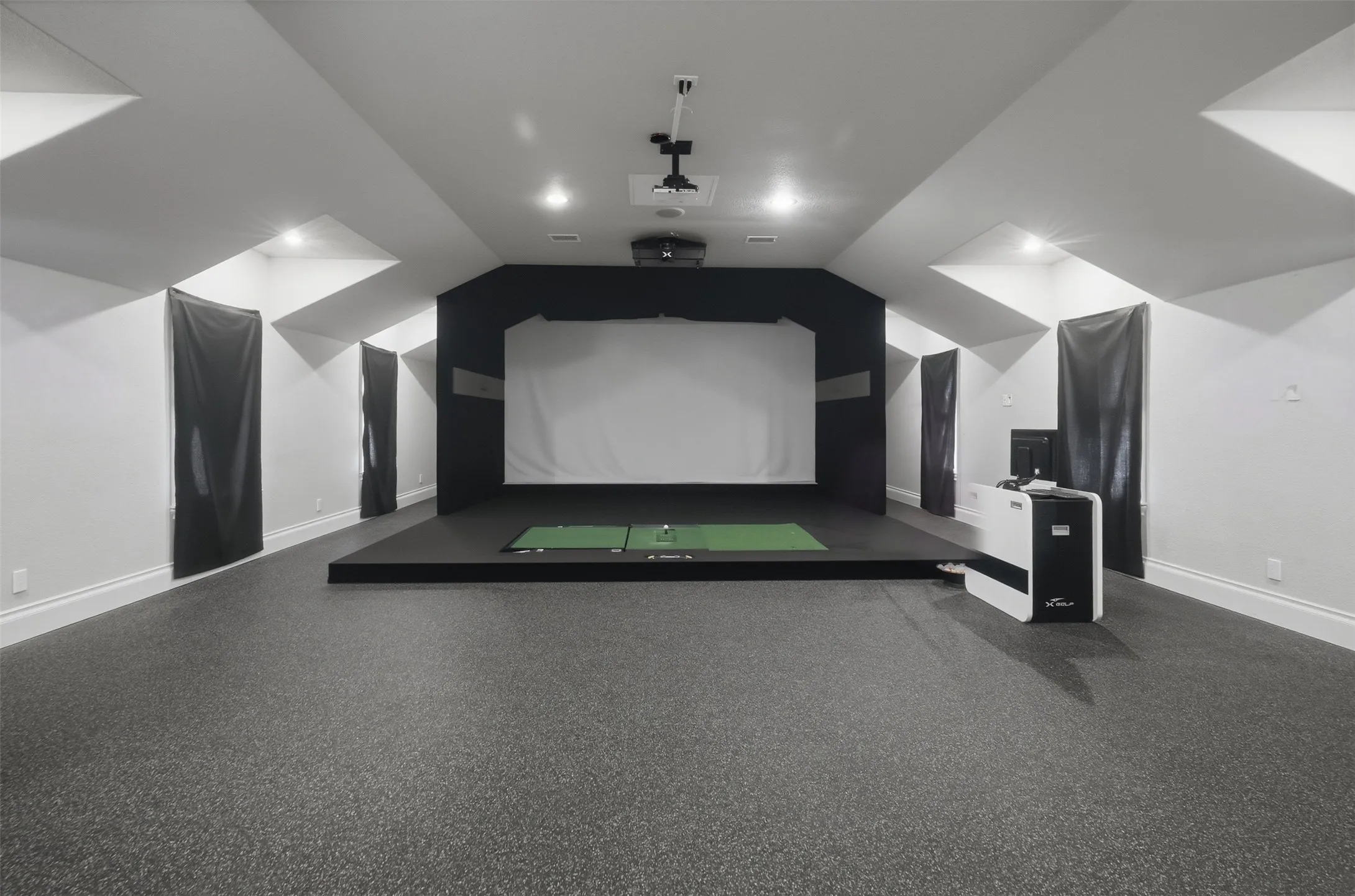 Every golfers dream~ The dedicated golf experience theater represents an investment of over $80,000, featuring a simulator that rivals the finest commercial installations available — a remarkable amenity that sets this home in a category of its own. This space has ample room to add home gym equipment as well.