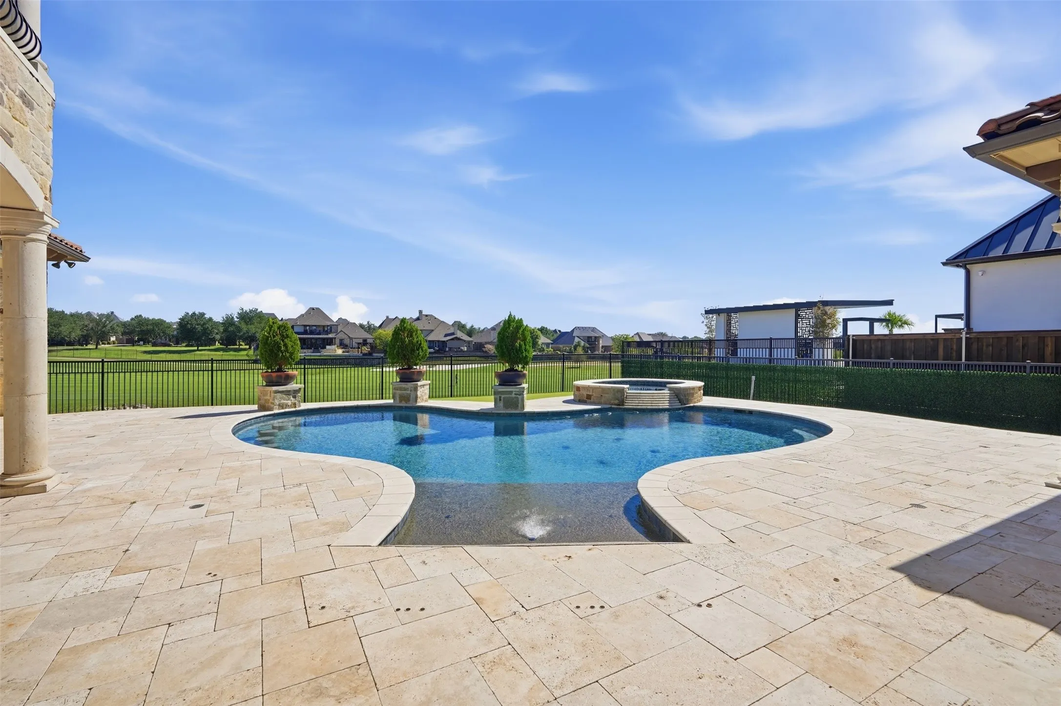 The custom pool and spa, designed and built by Lewis & Earley, features a Diamond Bright finish and a distinctive shape that anchors the backyard as a true focal point.