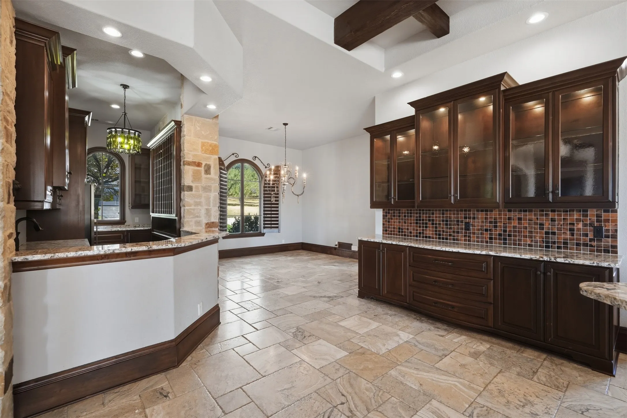 The wine and wet bar is appointed with generous cabinetry, a built-in ice maker, a full refrigerator, a large wine refrigerator, and ample built-in wine rack storage. A gorgeous butler's pantry with a built-in china cabinet connects seamlessly to the breakfast area.