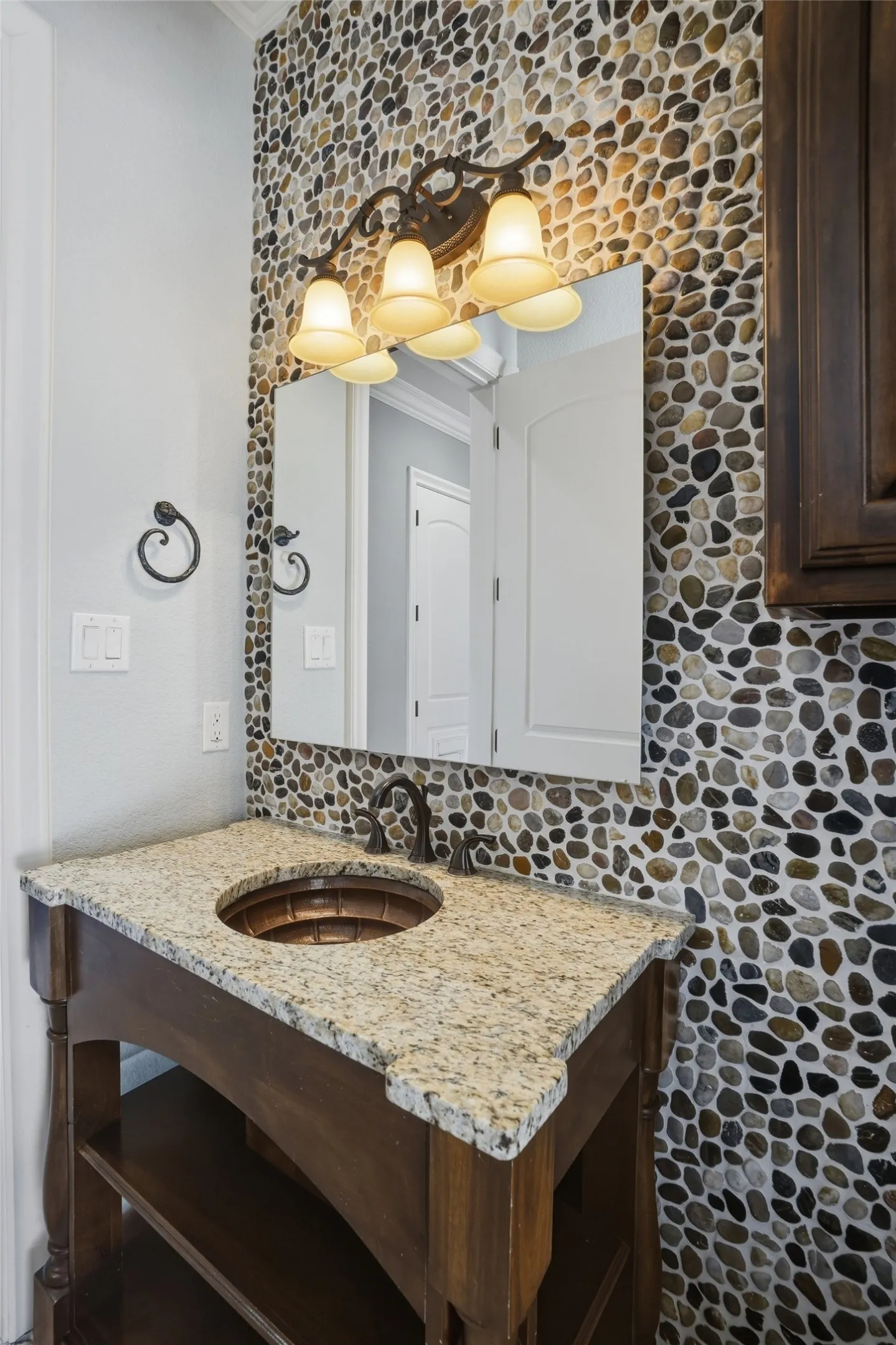 Pool bathroom downstairs with beautiful river rock backsplash