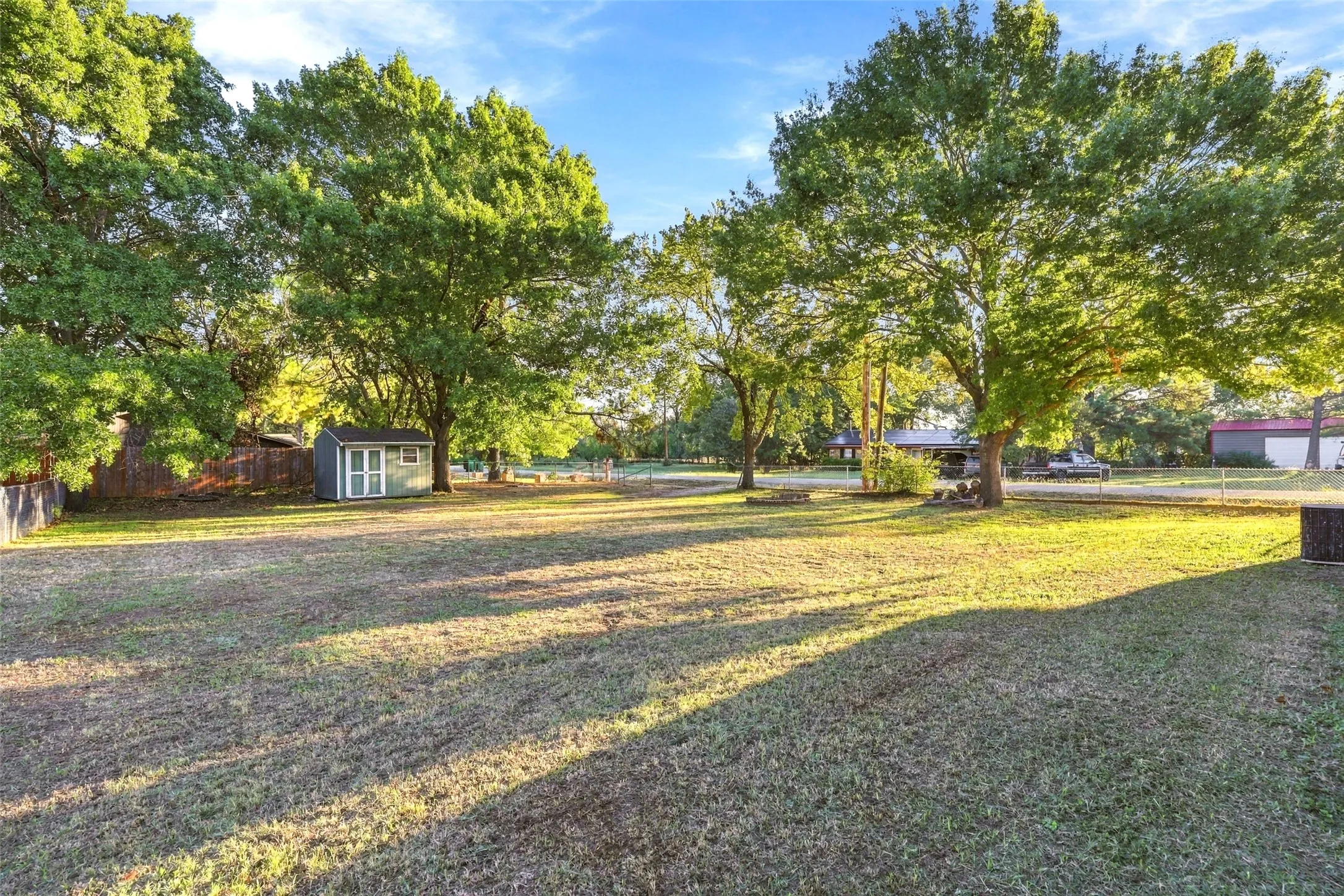 Backyard – Wide-open lawn with shaded areas and a convenient 12x8 storage shed.