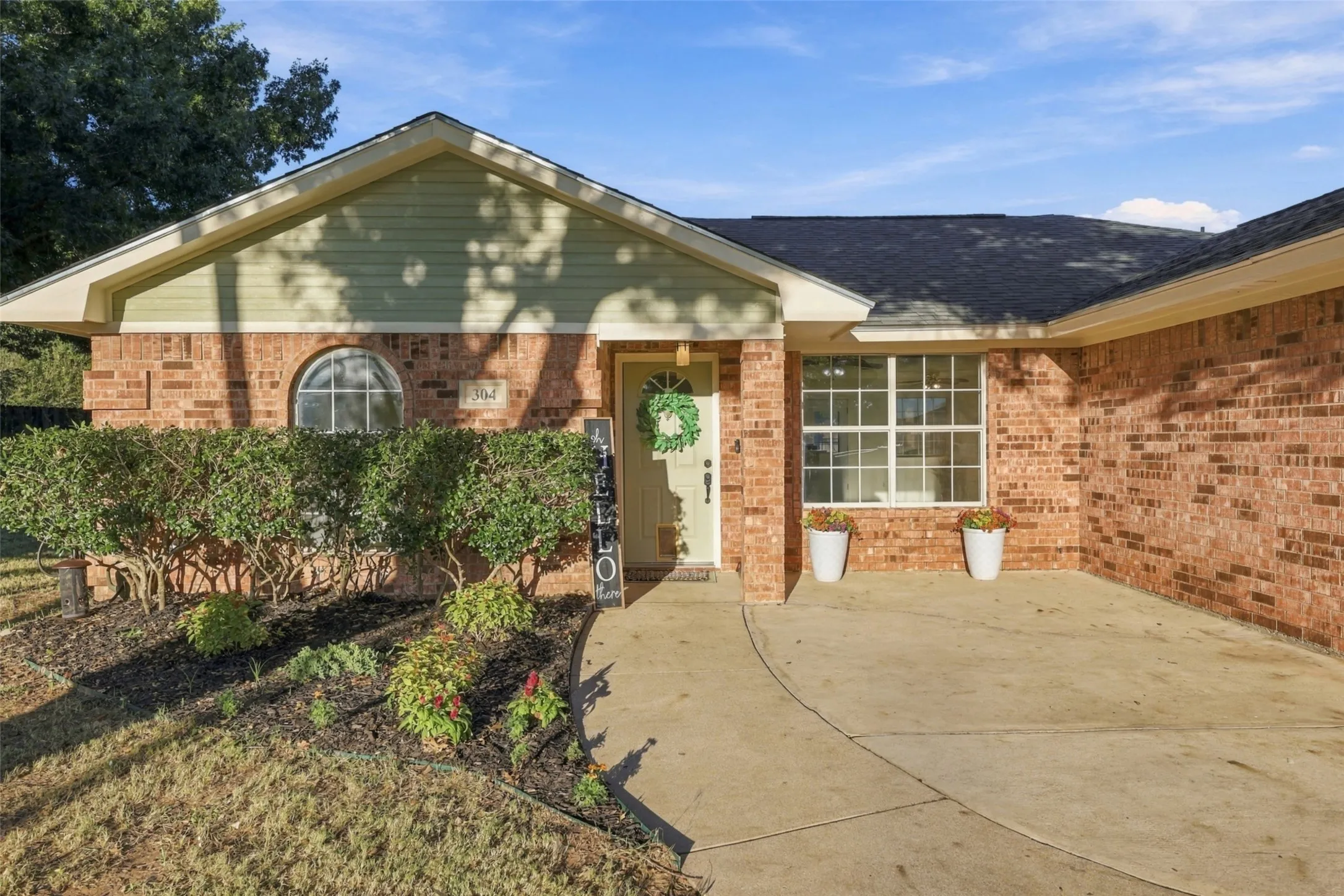 Front Porch – Fresh exterior paint, mature landscaping, and charming arched window.