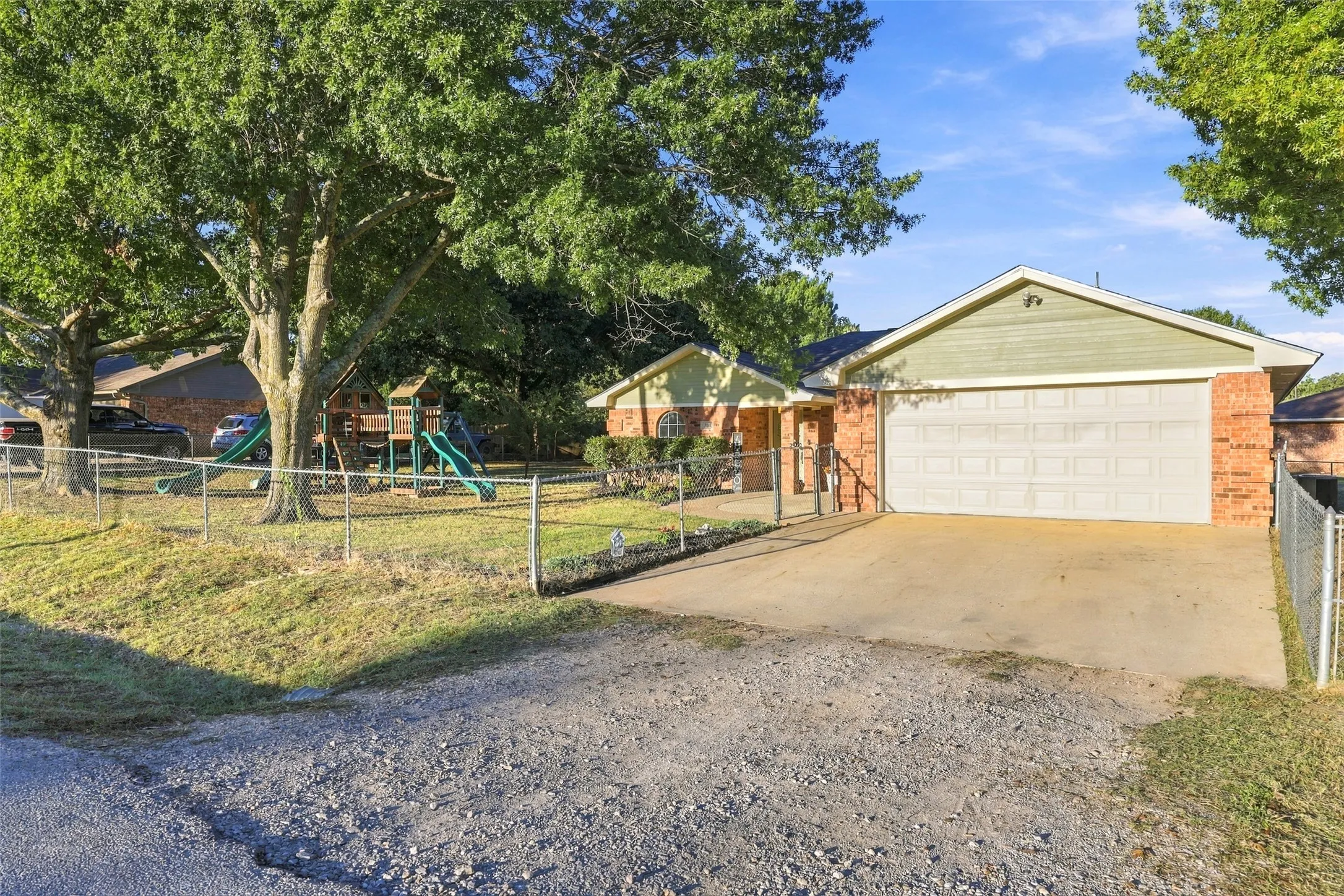 Driveway – Spacious concrete driveway with additional parking and attached two-car garage.