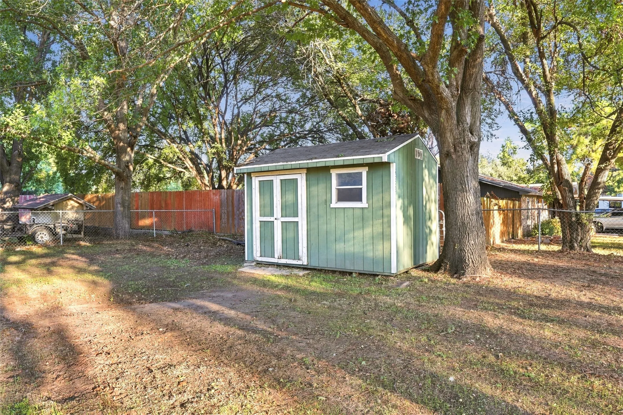 Storage Shed – Convenient backyard storage building nestled beneath mature trees.