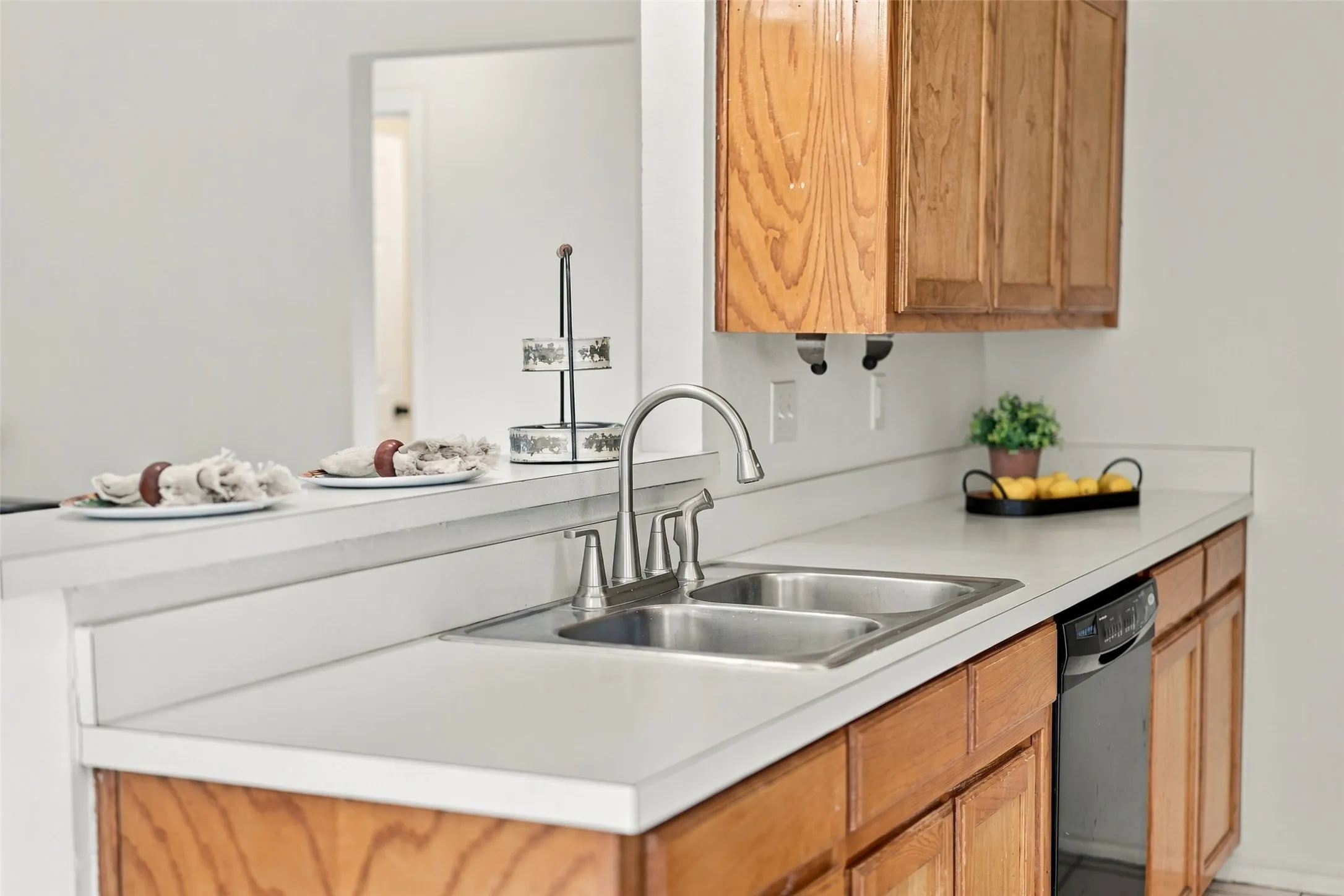 Kitchen – Breakfast bar, white countertops, double sink, and natural wood cabinetry.