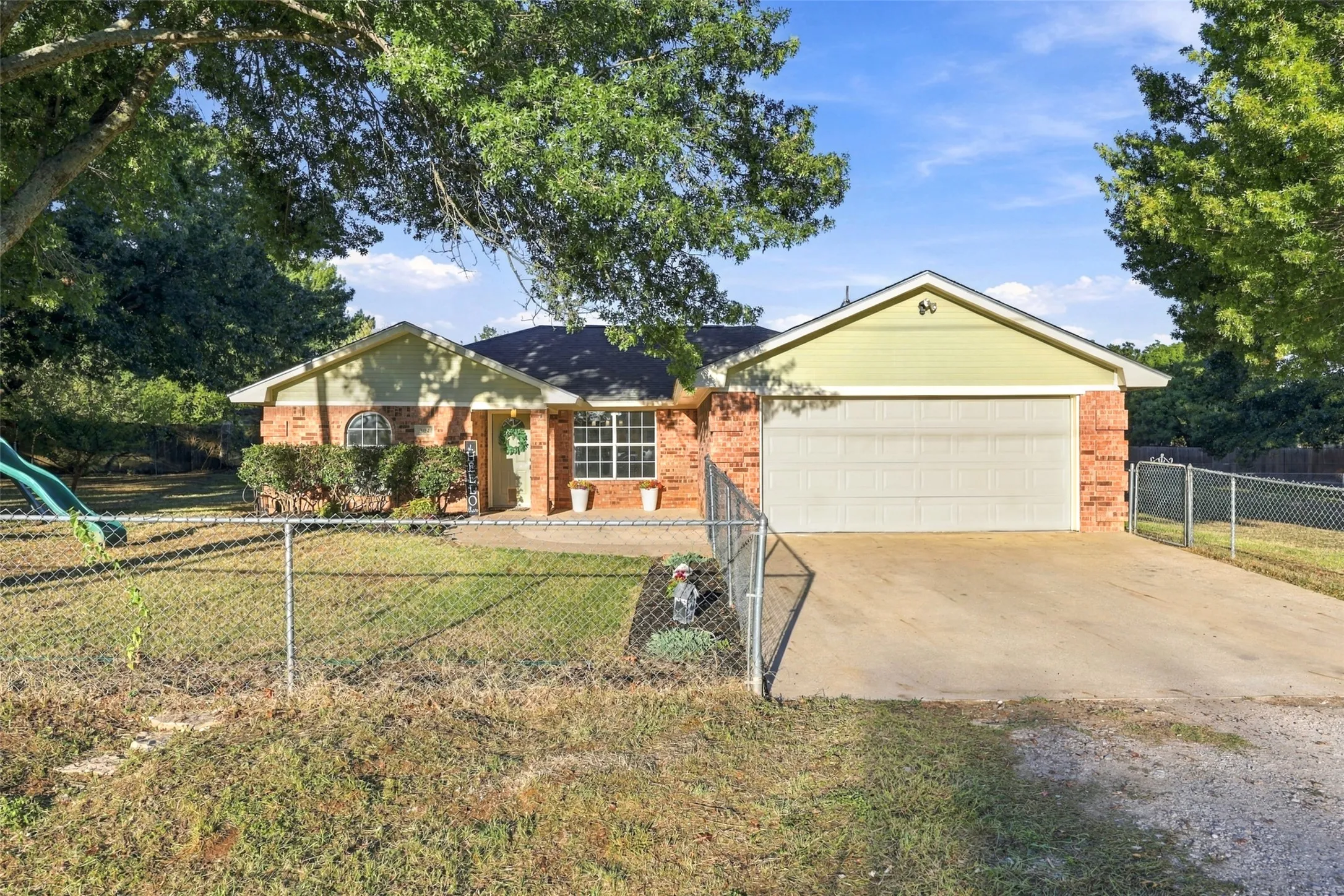 Front Exterior – Traditional brick home with attached two-car garage and gated front yard.