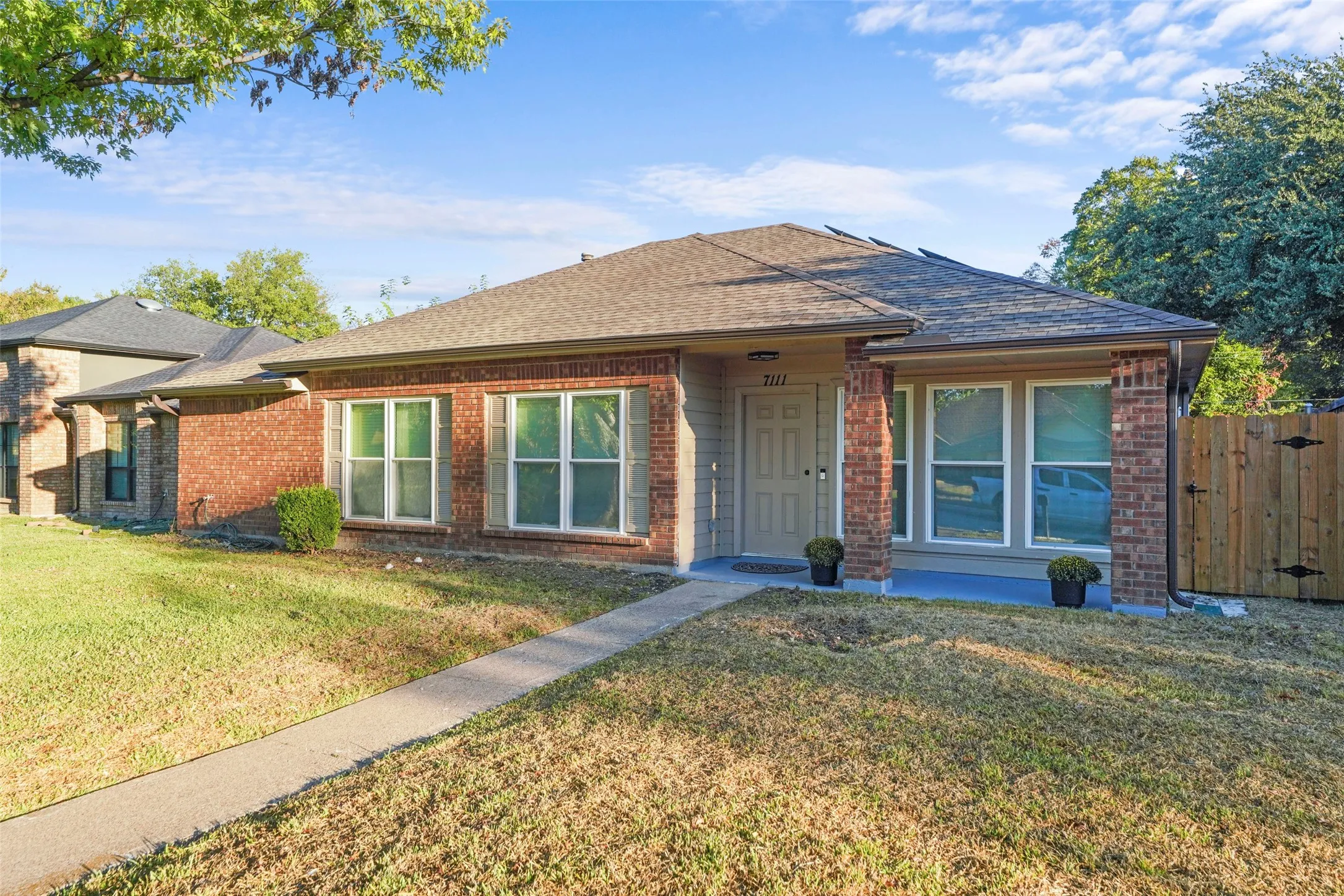 Brick exterior with a shingle roof and front porch
