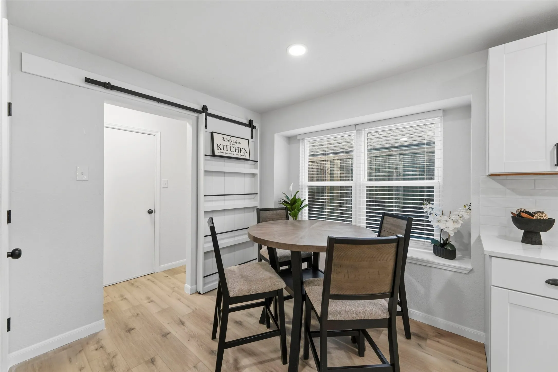 Wood-finish flooring, recessed lighting, and a barn door entry