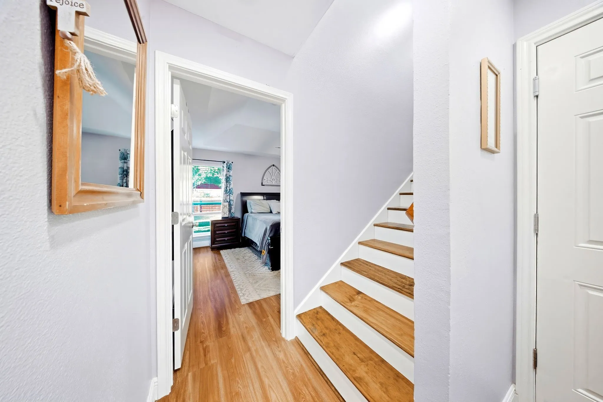 Wood-finish flooring, white painted risers, and light-colored walls