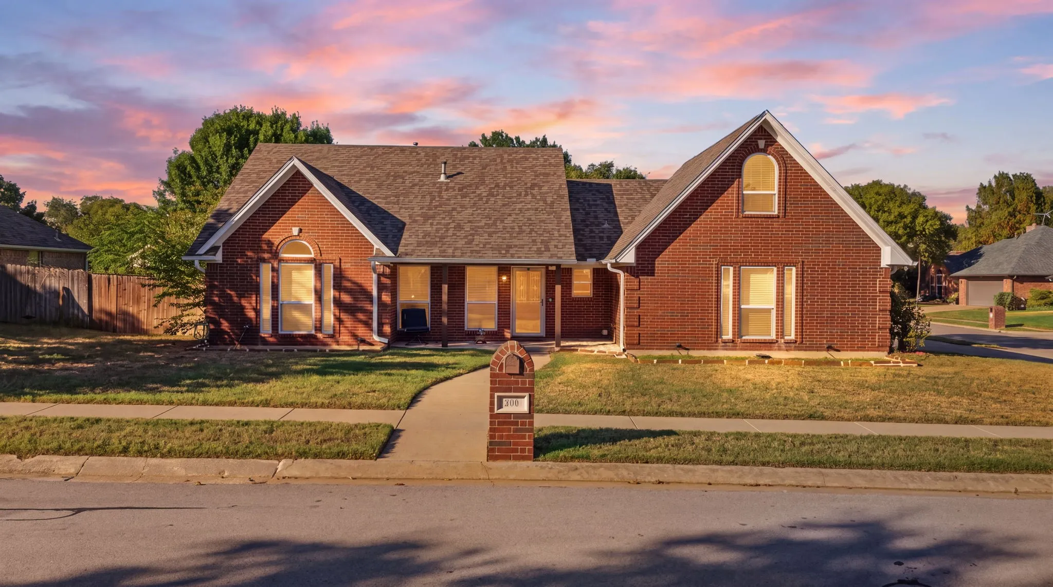Brick exterior with a gabled roofline, arched window details, and an integrated mailbox