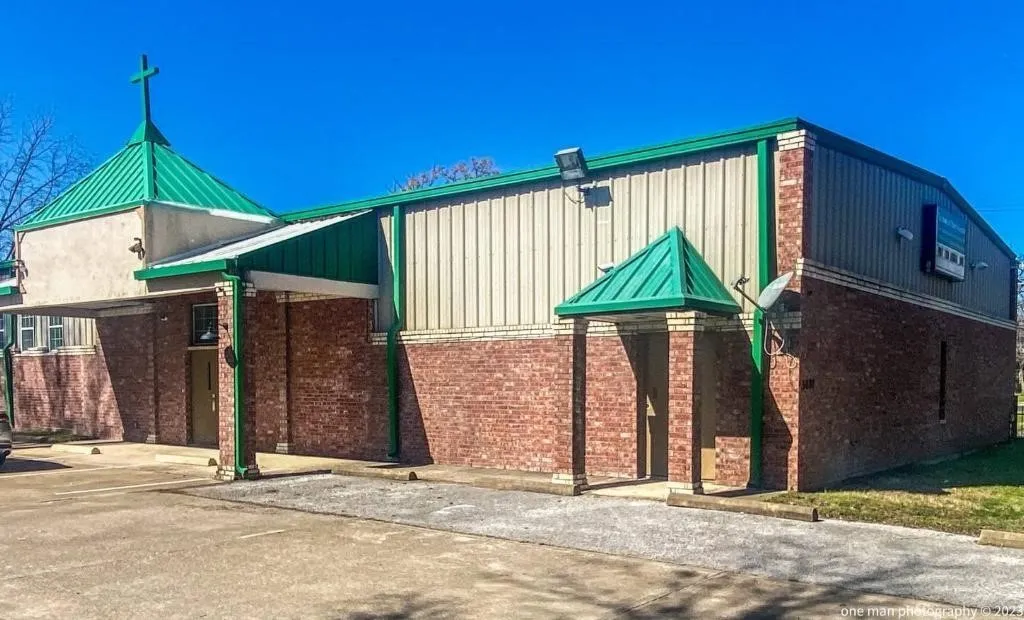 Brick and corrugated metal exterior with a green metal roof