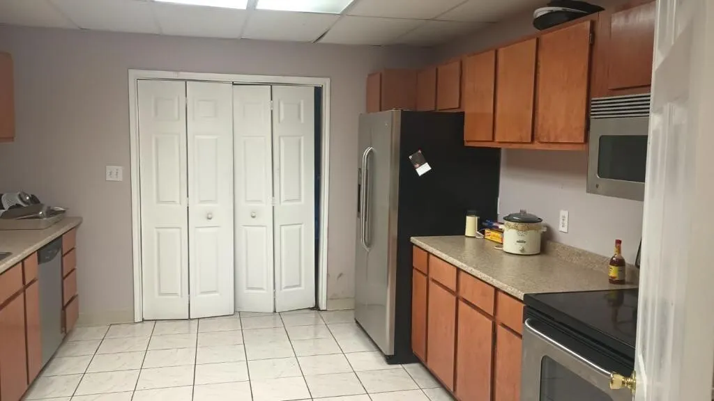 Kitchen with wood cabinetry, light-toned countertops, and tile flooring