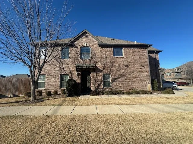 Brick exterior with complementary stone accents, covered entry, multiple window styles, and a gabled roofline