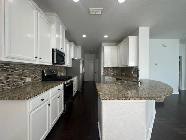 Kitchen featuring white cabinetry, granite countertops, tile backsplash, and dark wood-finish flooring