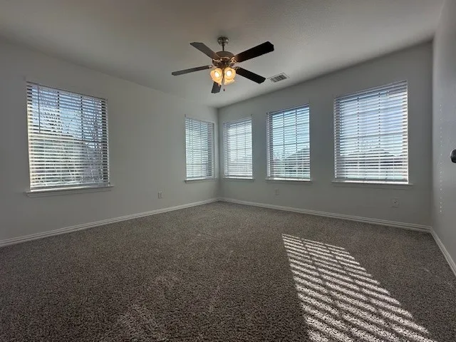 Plush carpeted flooring, multiple large windows with blinds, recessed lighting, and a ceiling fan with integrated lighting