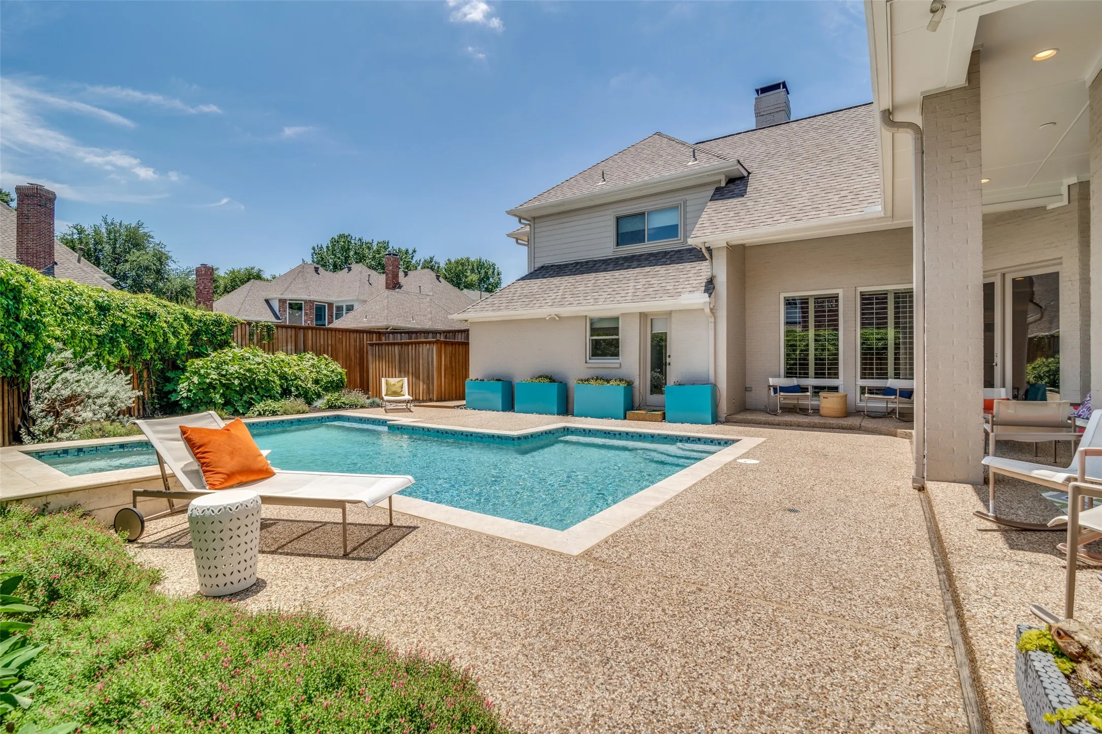Beautiful blooms along the fence line and greenery surround the pool
