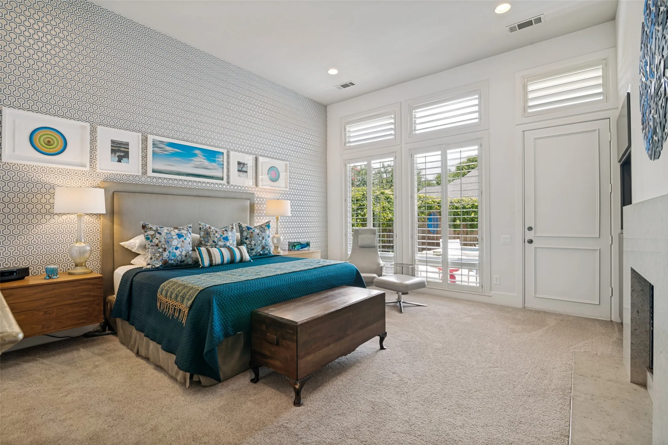 Natural light from oversize windows and access to the patio and pool. Floating nightstands are a sophisticated design touch.