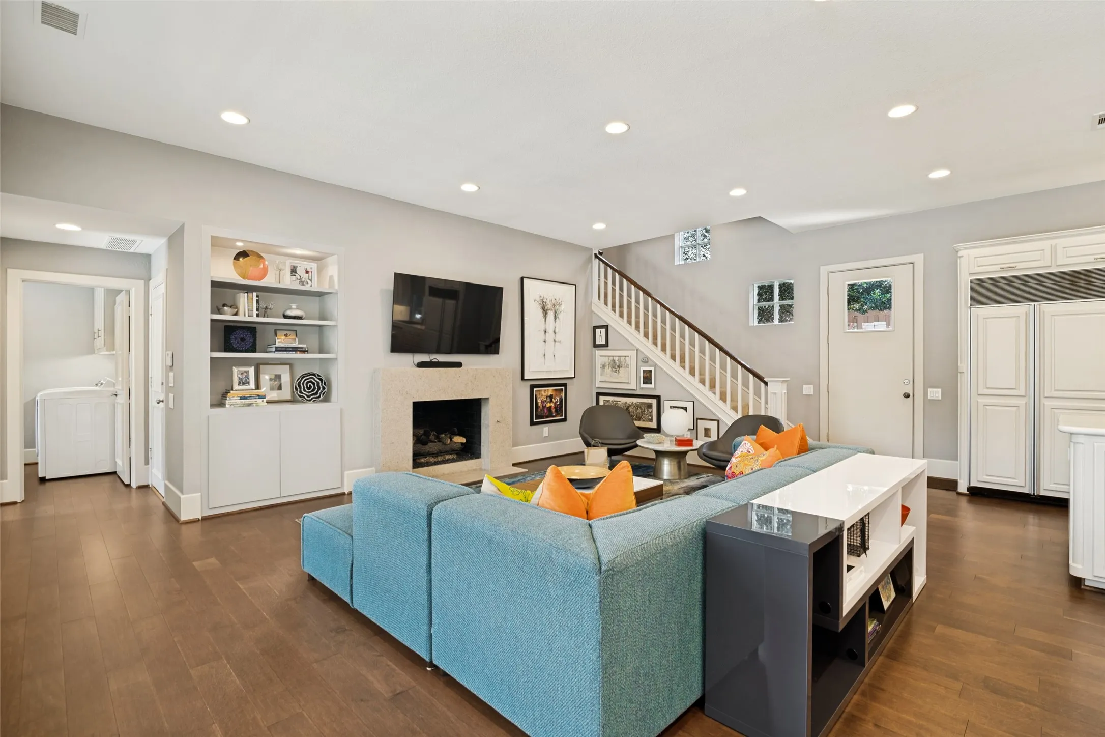 Casual and comfortable family room is a seamless, colorful extension of the kitchen! Second of the three fireplaces remodeled. The door on the right leads to a turfed side yard, perfect for pets