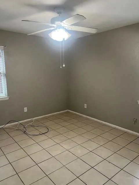 Neutral wall color, ceramic tile flooring, ceiling fan with integrated lighting, window with blinds