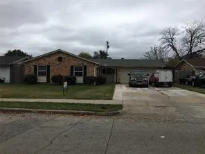 Brick exterior, attached garage, paved driveway, front lawn, mature landscaping