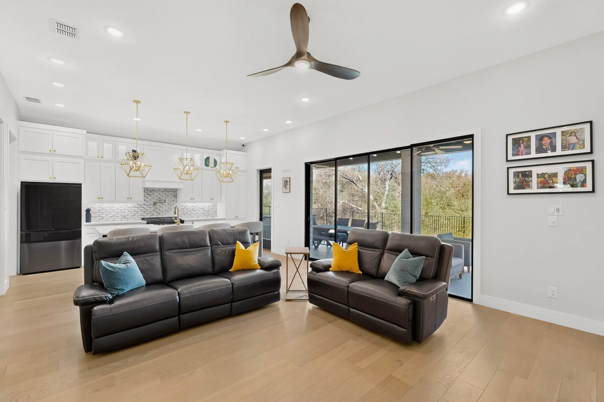 Open-concept living area with wood-finish flooring, recessed lighting, and a contemporary ceiling fan