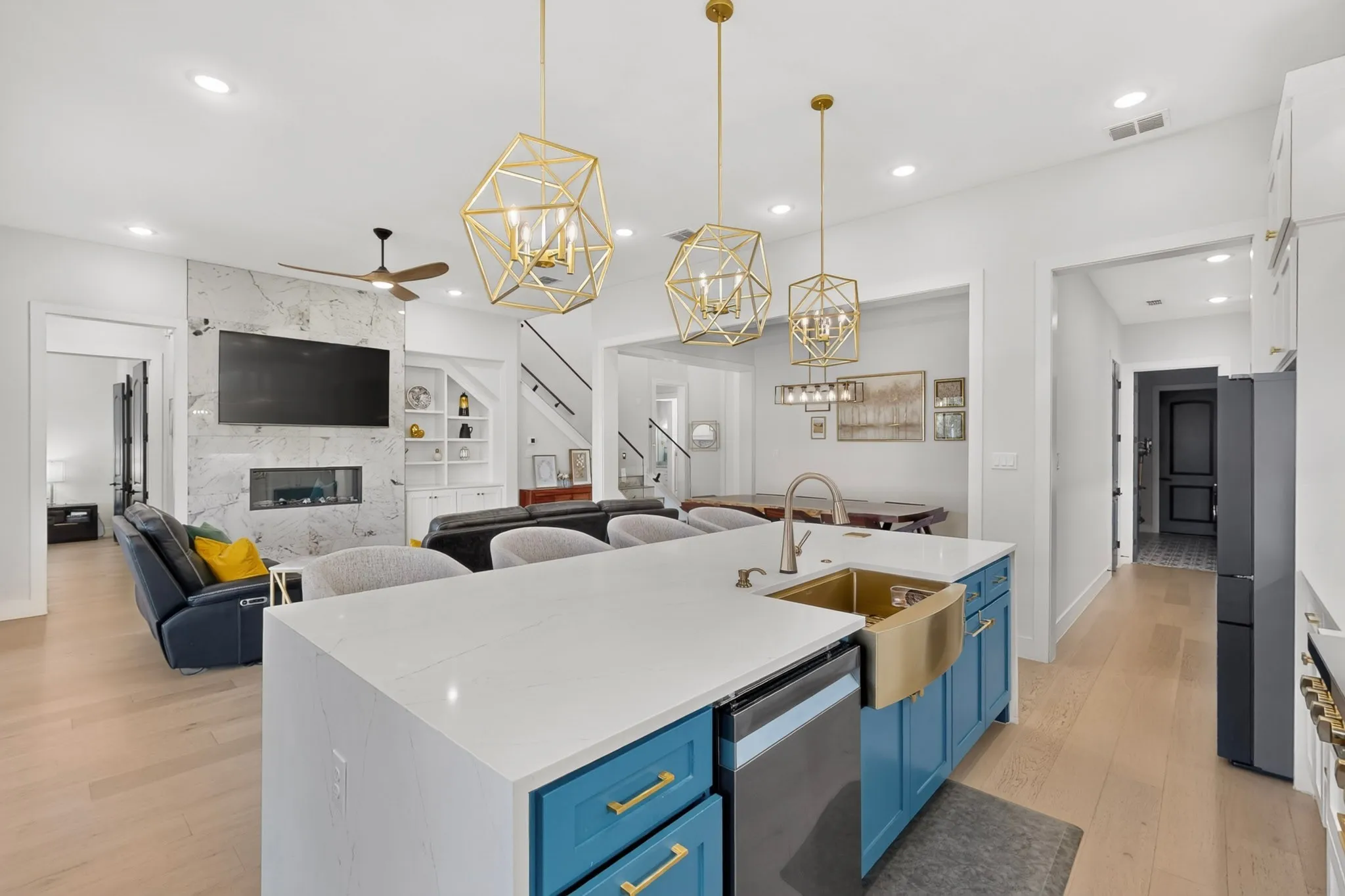 Gourmet kitchen with a large central island, gold-tone fixtures, and pendant lighting