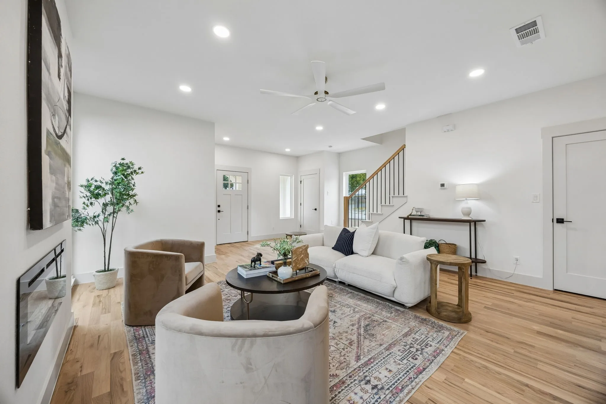 Recessed lighting, wood-finish flooring, a built-in electric fireplace, and a ceiling fan with light